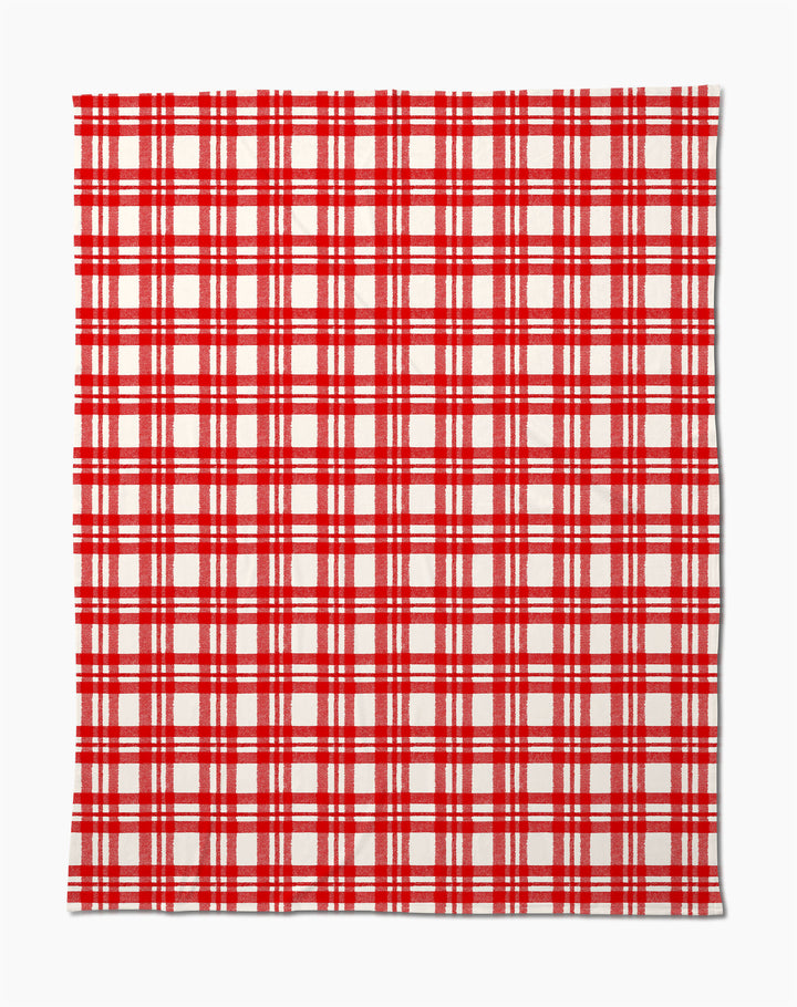 The Geometry Tartan Blanket features a red and white plaid design with red lines on a white background, making it a soft, cozy travel companion for comfort on the go.