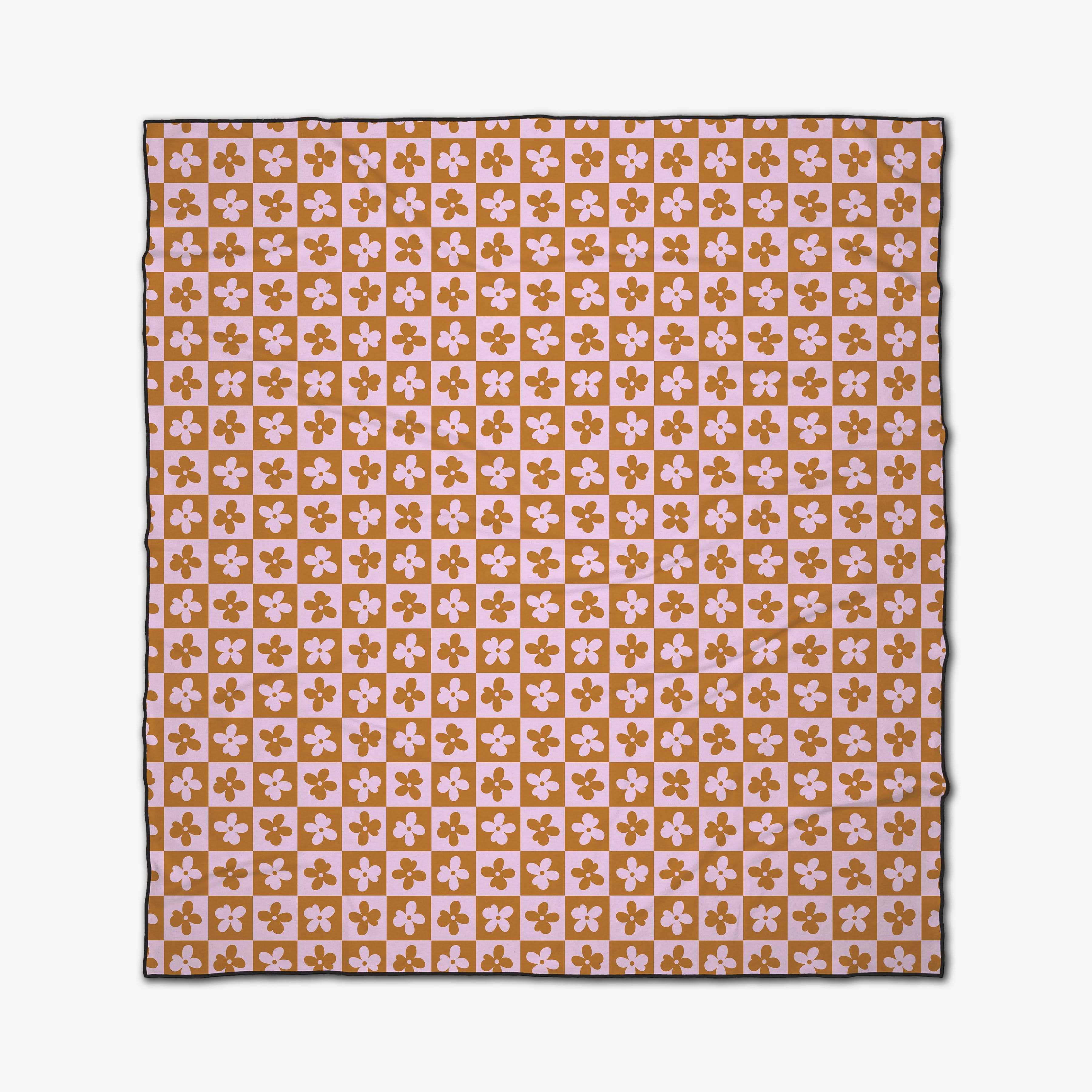 The Burnt Orange Flowers beach blanket by GEOMETRY features a square design with quick-dry fabric and a repeating pink and mustard checkerboard pattern adorned with four-petal florals, finished with a slim dark border.