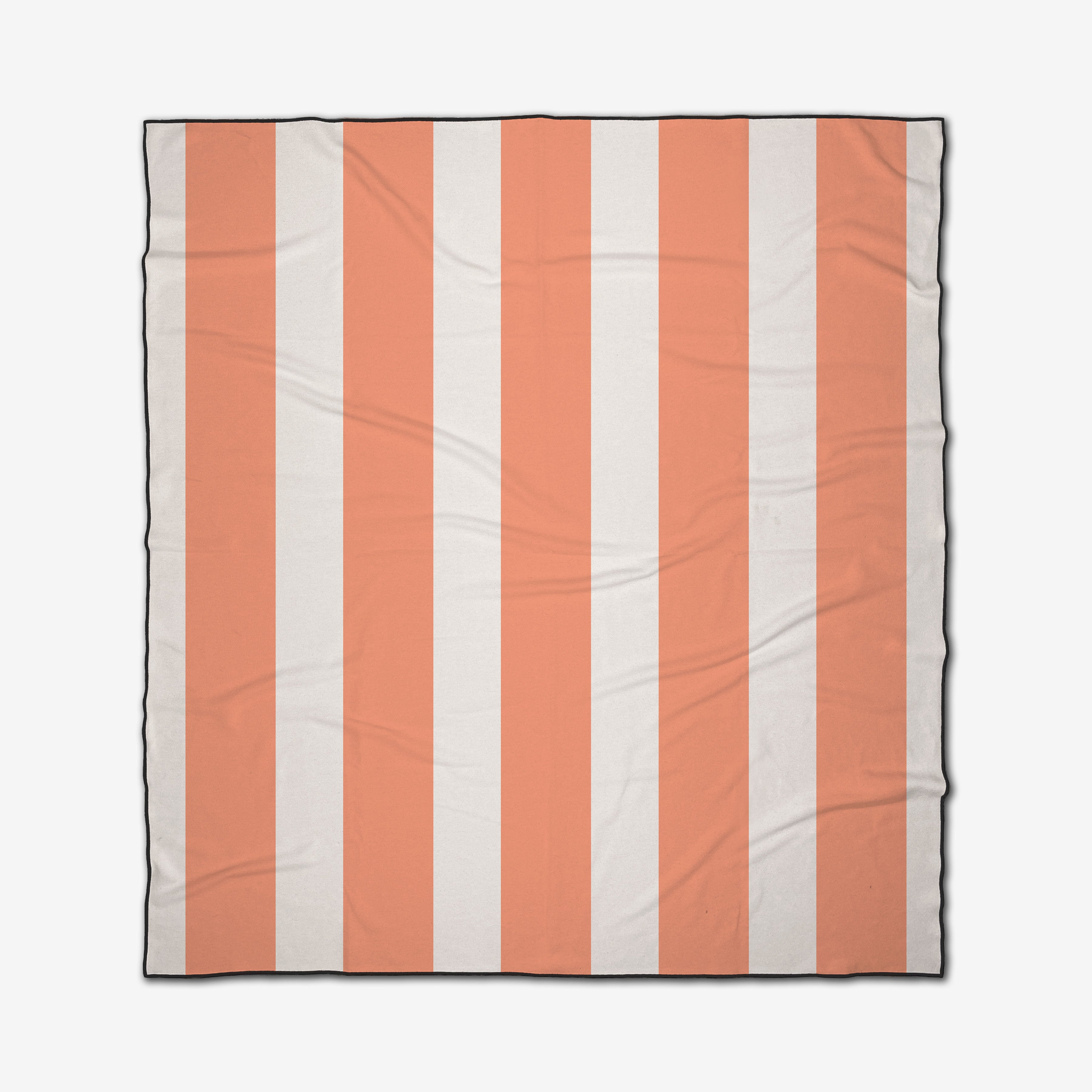 The GEOMETRY Coral Block Stripes is a square, quick-drying beach blanket with light orange and white vertical stripes, a thin black border, and a slightly wrinkled fabric appearance.