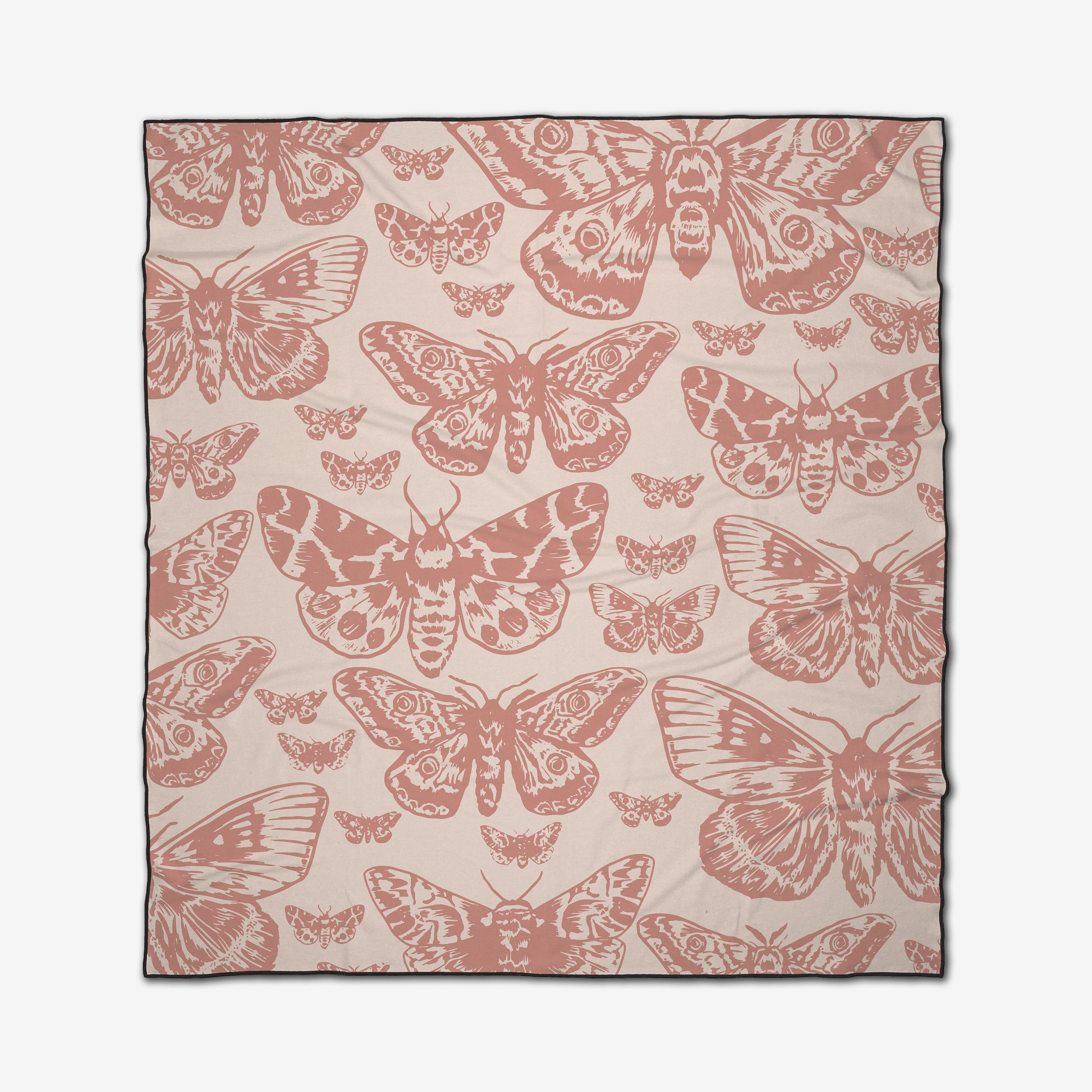 The GEOMETRY Mauvy Moths is a beige compact beach blanket made from recycled materials, featuring a repeating pattern of pink and rose-colored moth illustrations.