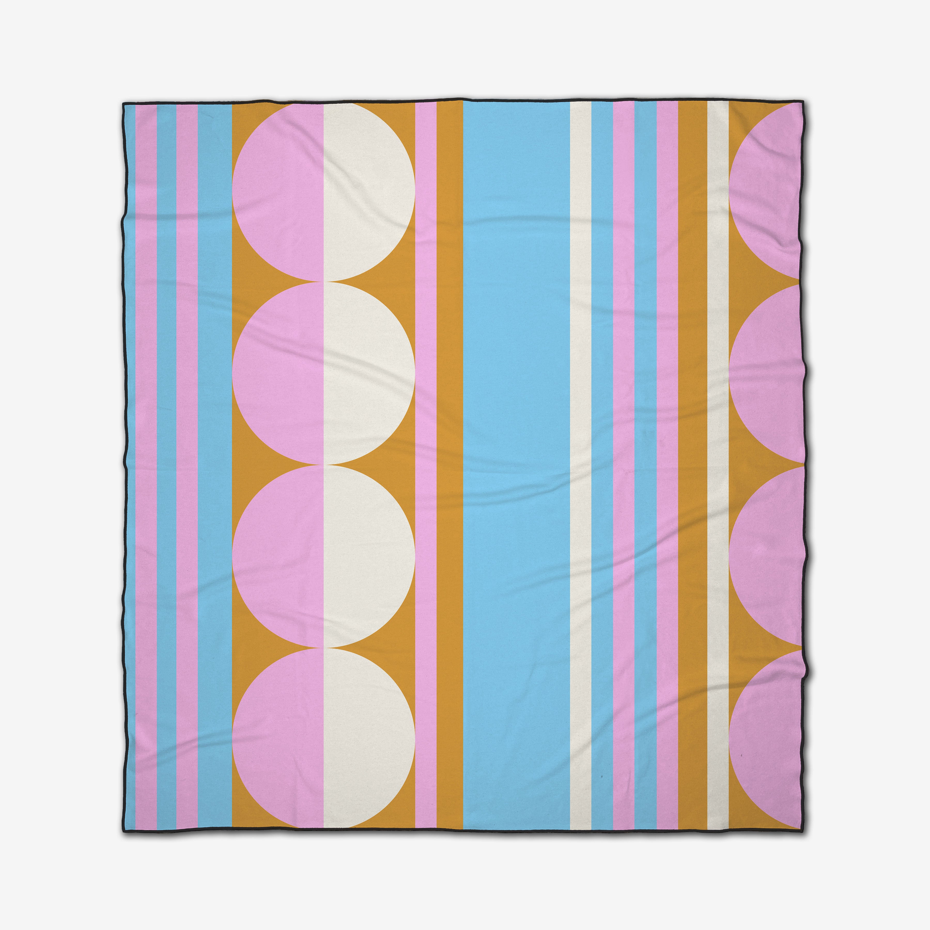 The GEOMETRY Turmeric Pinks beach blanket is quick-drying, with a geometric pattern of blue, pink, orange, and white vertical stripes accented by large pink and white circles along the edges.