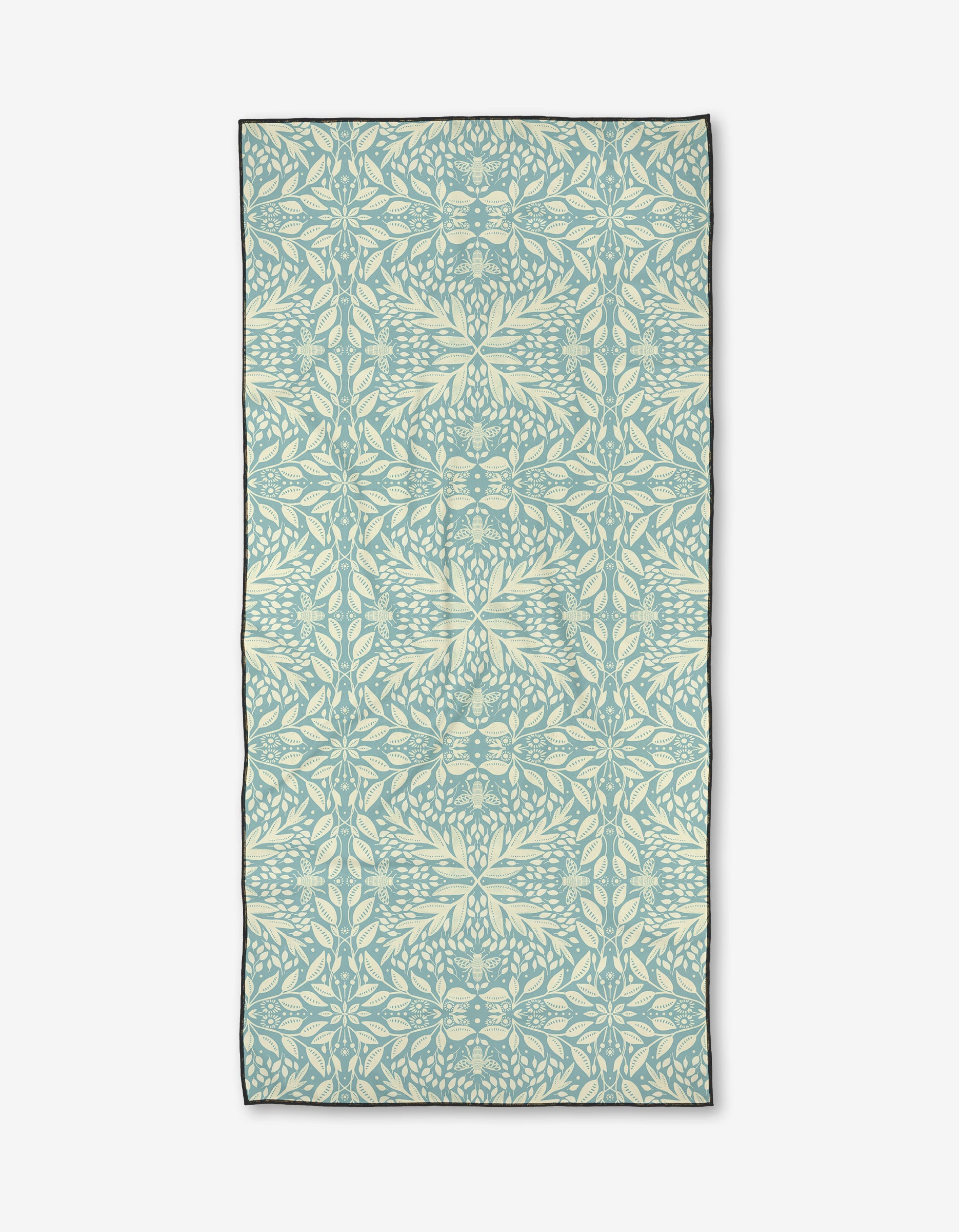 Bee Magic by Katie OShea is a rectangular micro-loop beach towel made from recycled materials, showcasing a pale blue and cream symmetrical leaf and vine pattern in an intricate botanical design on a white background.