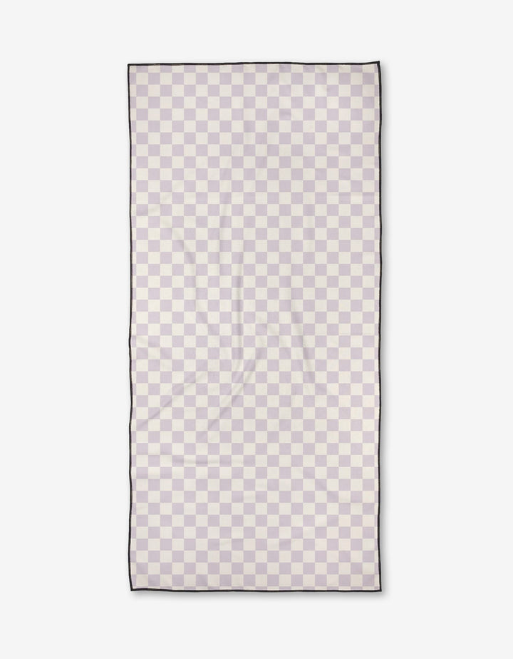 The Check Please Beach Towel by Kelsi Fullmer features a rectangular geometric checkerboard in light beige and pale gray, thin black edging, and is made of quick-drying, recycled materials. Shown flat on a white background.