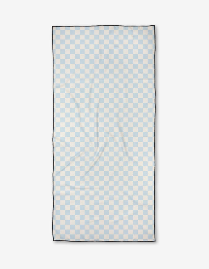 Checked Out by Kelsi Fullmer: A rectangular towel with a light blue and white checkerboard design, thin black border, and ultra-absorbent quick-dry fabric, shown flat on a plain white background.