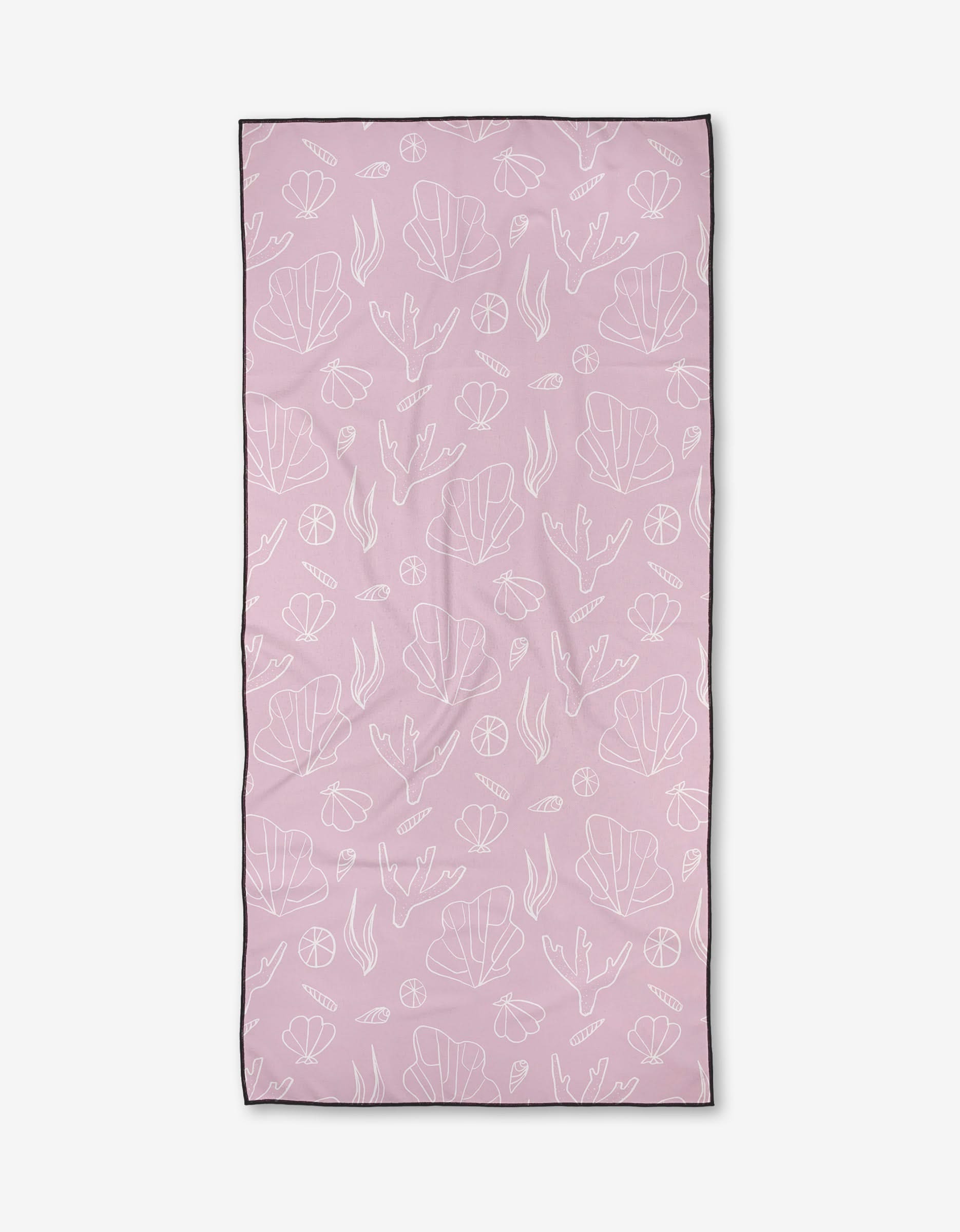 The Coral Cove beach towel by Janna Sue Design is rectangular, light pink, made from recycled materials, and features white outlines of seaweed, shells, and underwater plants with a slim dark border.
