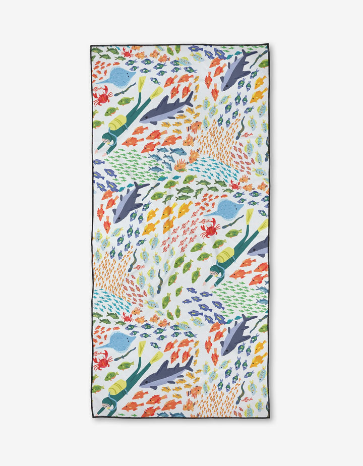 The Deep Sea Encounter towel by Janna Sue Design is a rectangular, quick-drying, eco-friendly beach essential. It showcases colorful divers, sharks, and fish on white, made from recycled materials.
