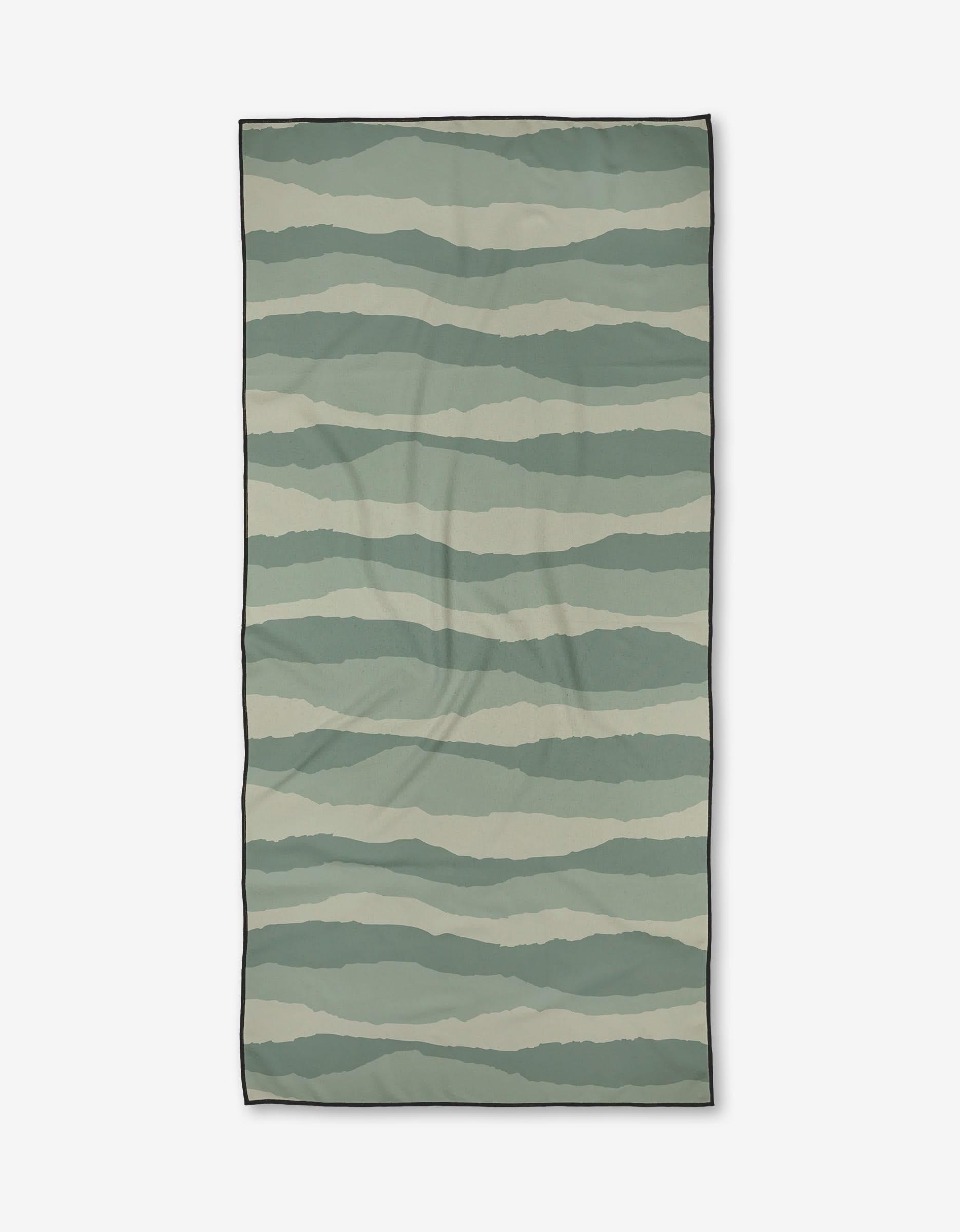 The Twig + Spark Distant Landscape Micro-loop Beach Towel features horizontal wavy stripes in green and beige, a thin black border, and is made from quick-drying, post-consumer recycled materials.