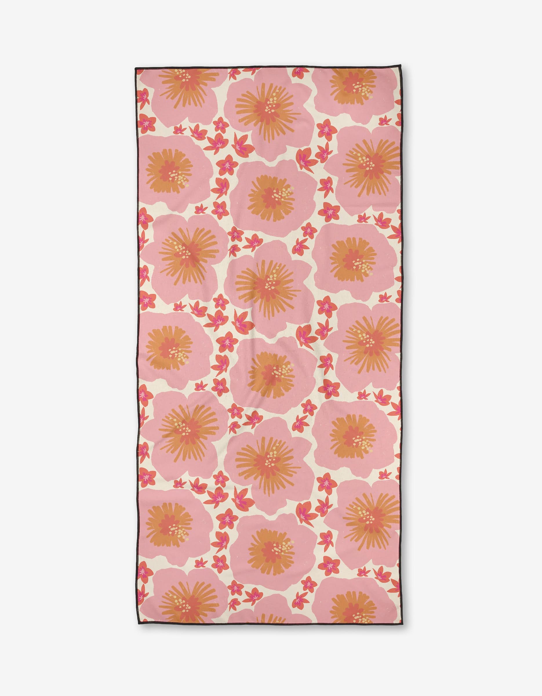 The Janna Sue Design Hibiscus Sunset beach towel features large pink and orange stylized flowers with yellow centers and small pink accents on a light background. Made from quick-drying recycled materials, it is bordered in dark trim.