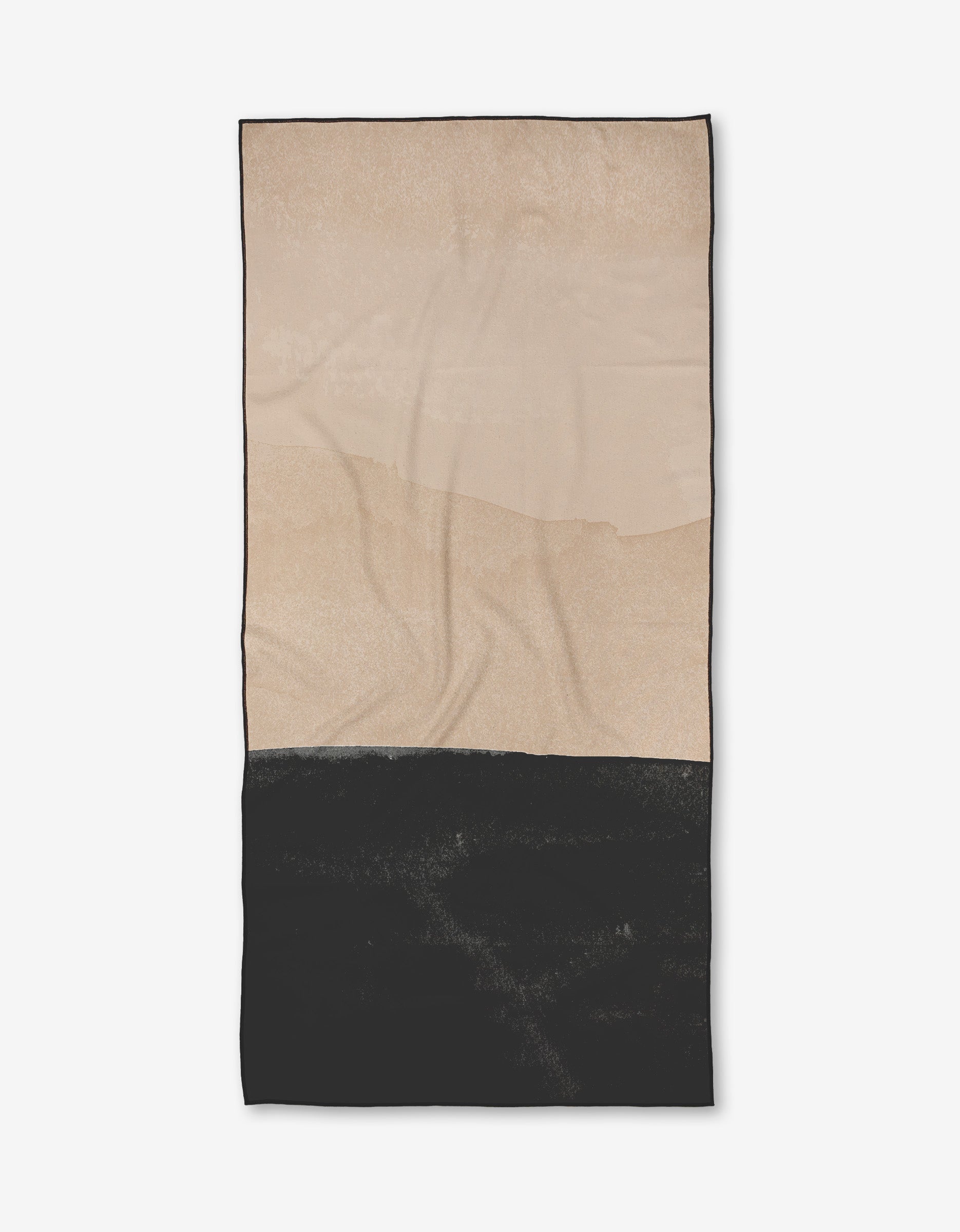 The Jojo towel by Kailee Wright is a rectangular, quick-drying towel made from recycled materials. It has a minimalist look with a beige upper half, solid black lower half separated by an uneven line, and naturally shows slight wrinkles.