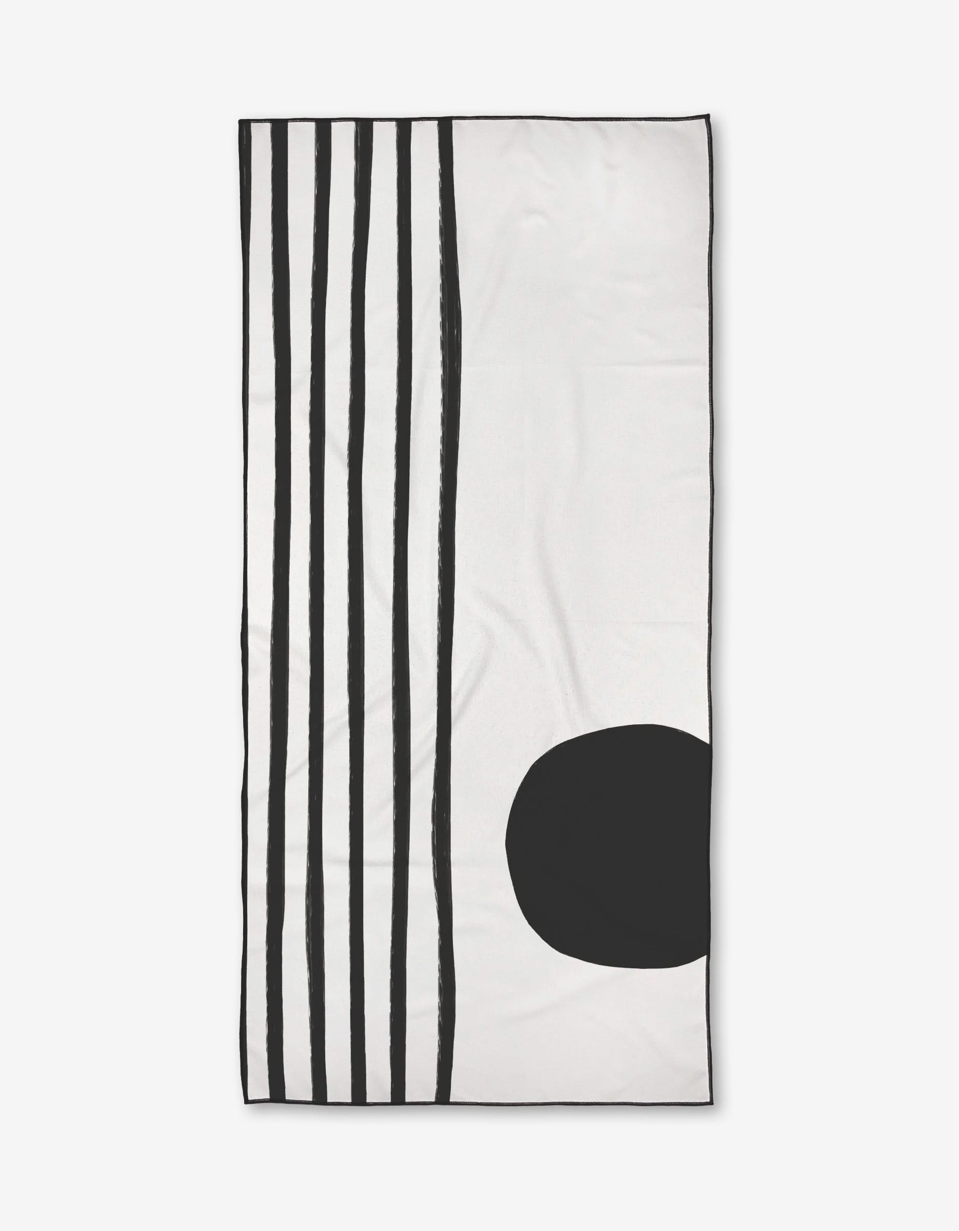 The Laurz beach towel by Kailee Wright is rectangular, white, and features five vertical black lines on the left side with a large solid black oval at the lower right.
