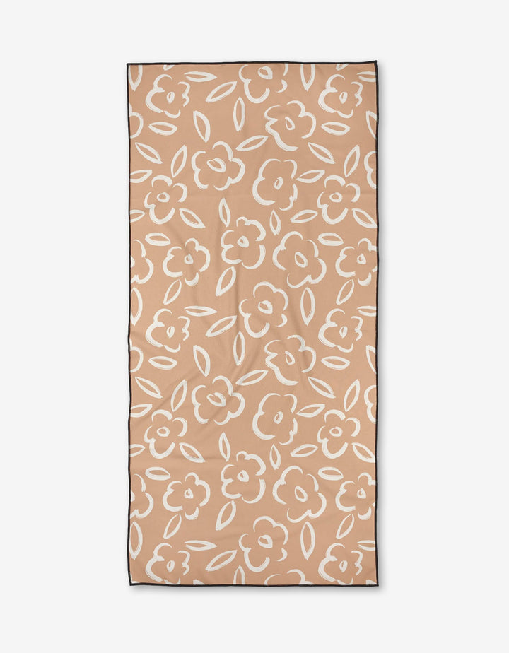 The Painted Bloom towel by Hufton Studio features a rectangular beige micro-loop fabric with white outlined floral and leaf patterns, bordered by a thin black edge, shown flat against a white background.