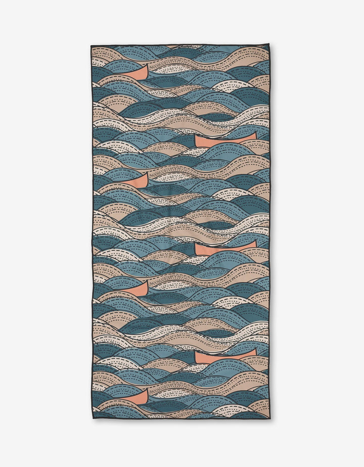 Twig + Spark Squall Micro-loop Beach Towel: Rectangular towel with abstract wave patterns in blue, beige, cream, and tan on a white background. Crafted from quick-drying recycled materials.