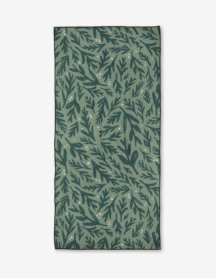 Trail Dusting by Twig + Spark is a rectangular green fabric made from recycled materials, showcasing a dark and light green leafy botanical pattern with off-white dots on a white background.