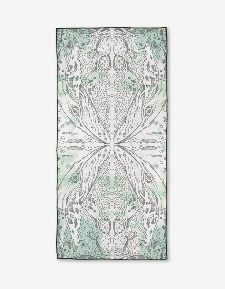 The Skye Walker Whale Micro-loop Beach Towel features a rectangular shape and an abstract, symmetrical design in soft green, grey, and white tones. Made from post-consumer recycled materials, it is shown laid flat on a white background.