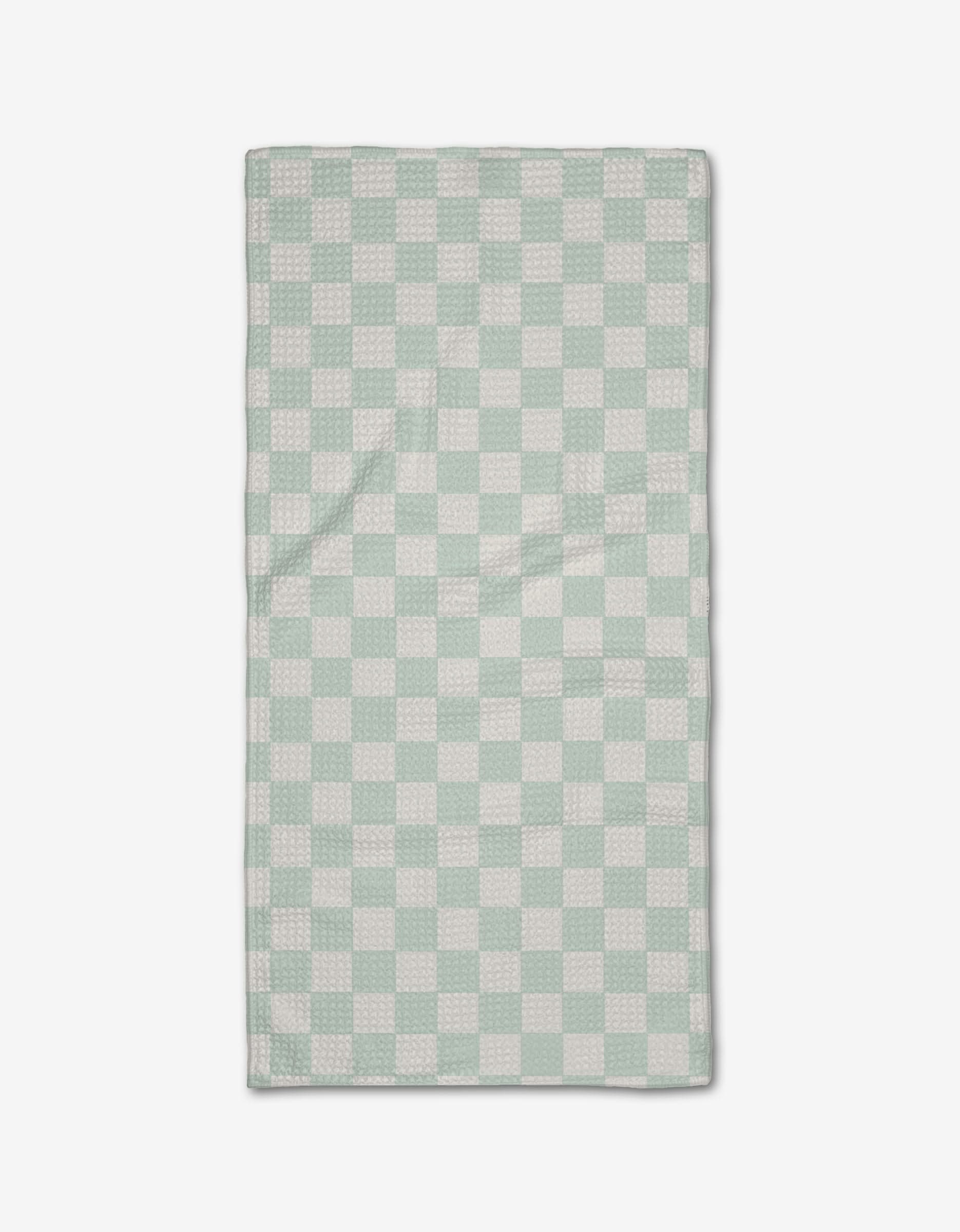 The Sweet Simple Vegan Pastel Picnic towel, made from Geoweave fabric and featuring a light green and white checkerboard pattern, is laid flat on a white background.
