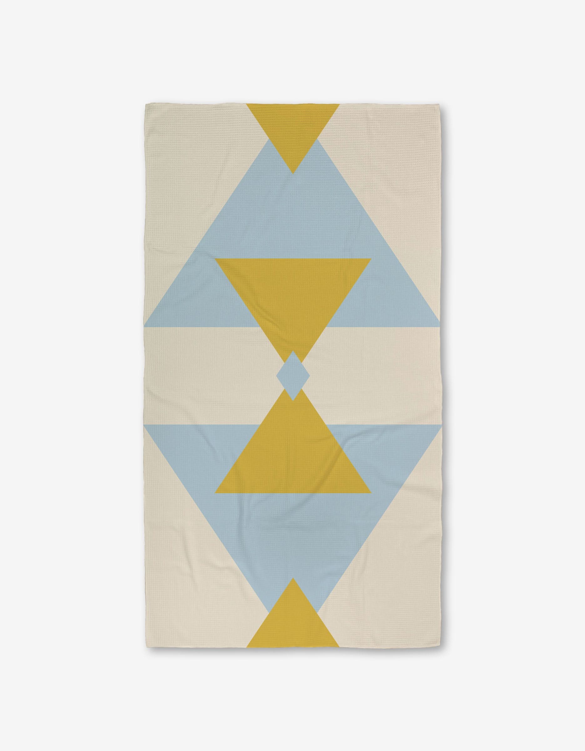 The GEOMETRY Balanced Blue blanket features a geometric pattern of yellow and blue triangles and diamonds on a cream background, with bold, symmetrical shapes running vertically. Made with ultra-absorbent Geoweave technology.