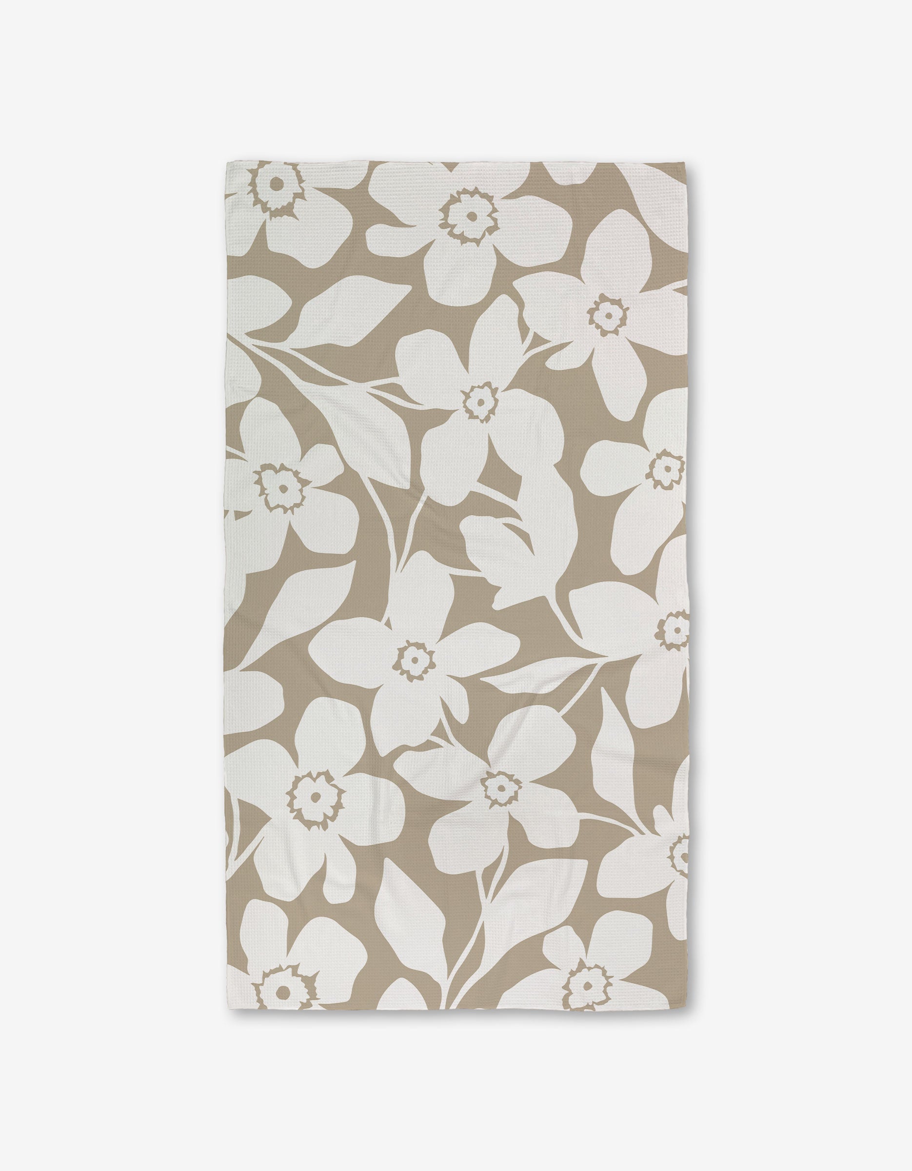 A GEOMETRY Big Tan Flowers Luxe Bath Towel, featuring a white floral pattern of large flowers and leaves made with Geoweave technology, is shown flat on a white background.