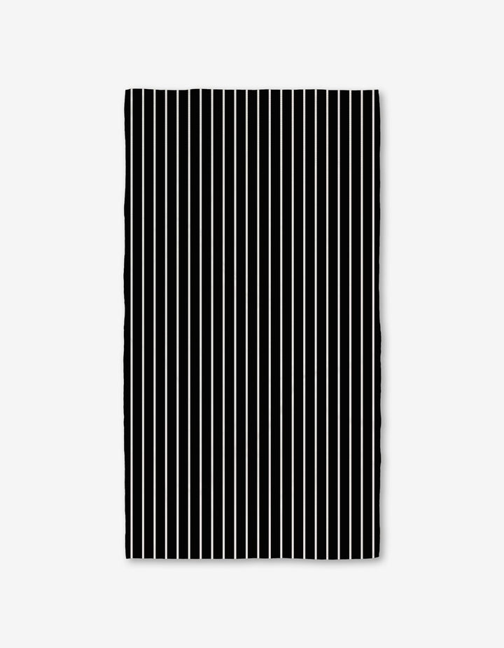 The GEOMETRY Black Linen Bath Towel features evenly spaced vertical black and white stripes on a plain white background, with slightly wavy edges that highlight its ultra-absorbent Geoweave technology.