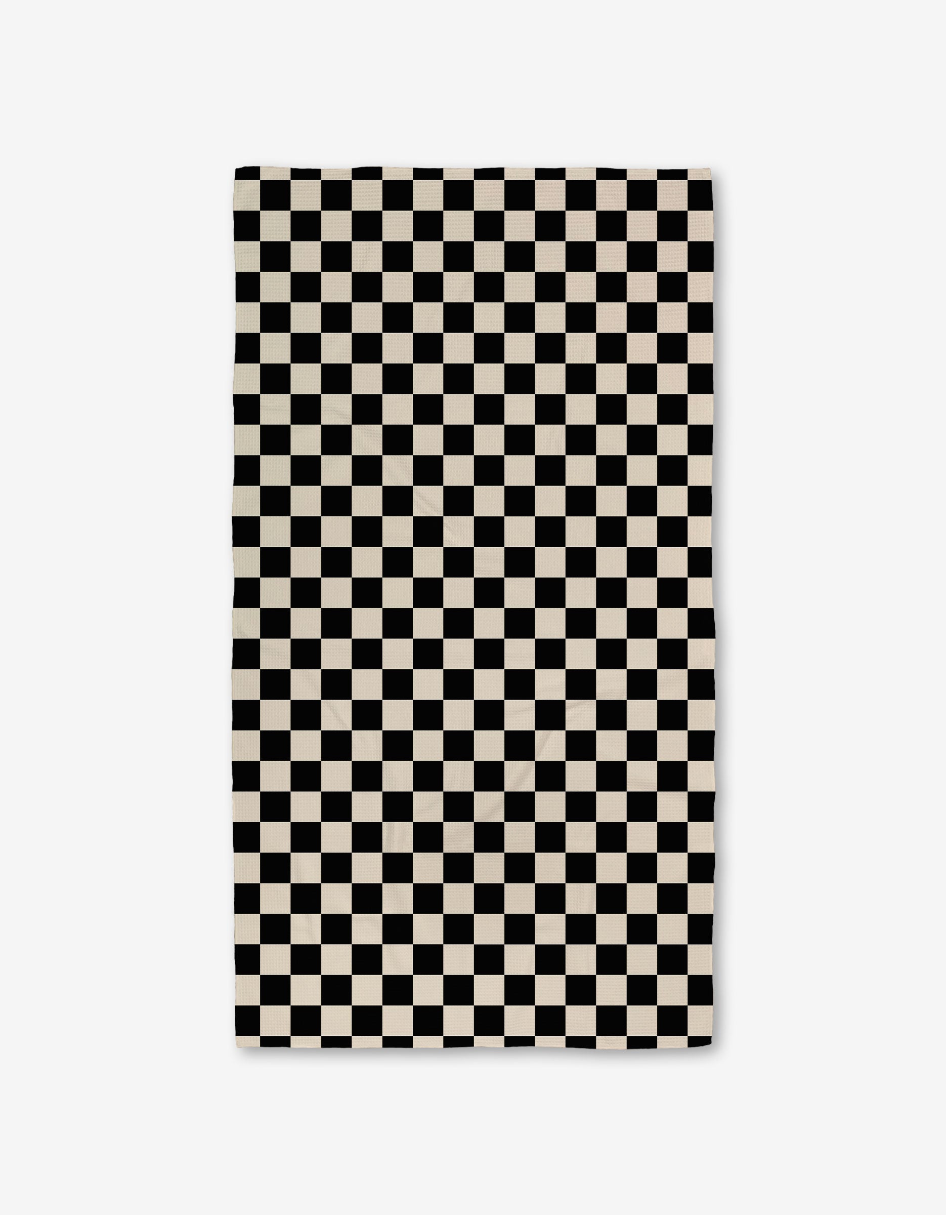 The GEOMETRY Checkered Luxe Bath Towel, featuring Geoweave technology and a black-and-white checkerboard pattern, offers an ultra-absorbent experience against a crisp white background.