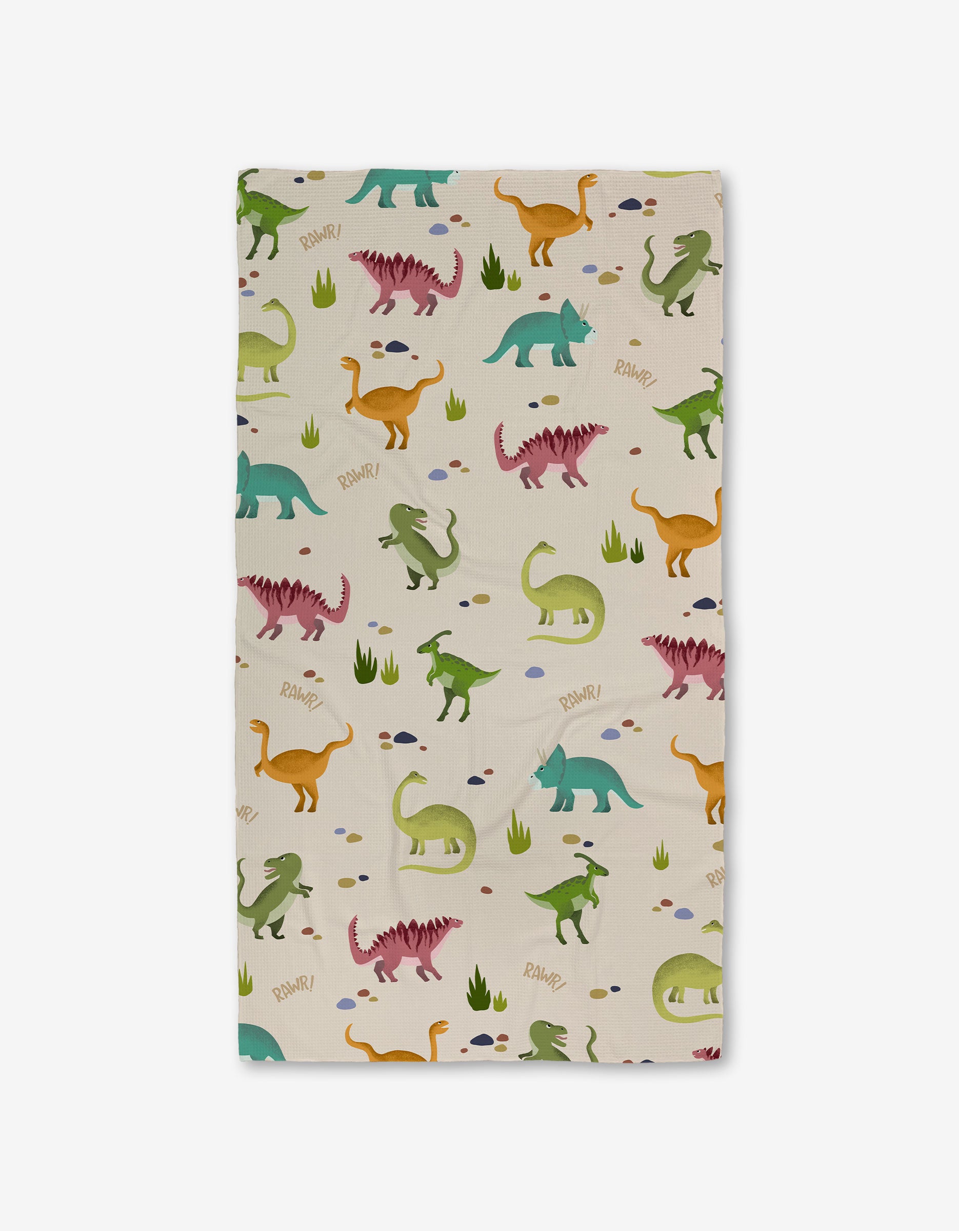 GEOMETRY’s Dancing Dinos Bath Towel, rectangular with a playful dinosaur pattern in green, orange, pink, and blue on cream with grass and rocks. Features ultra-absorbent Geoweave technology and “RAWR!” text near some dinos.