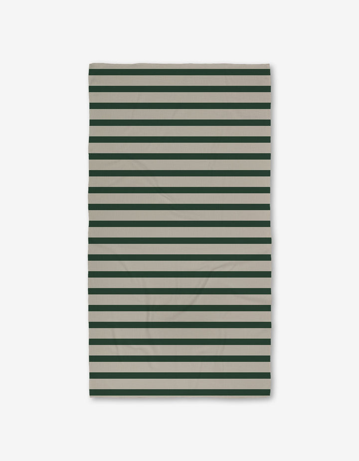The GEOMETRY Deep Green Stripes Luxe Bath Towel, made from recycled materials and featuring horizontal dark green and beige stripes, is shown flat on a white background.