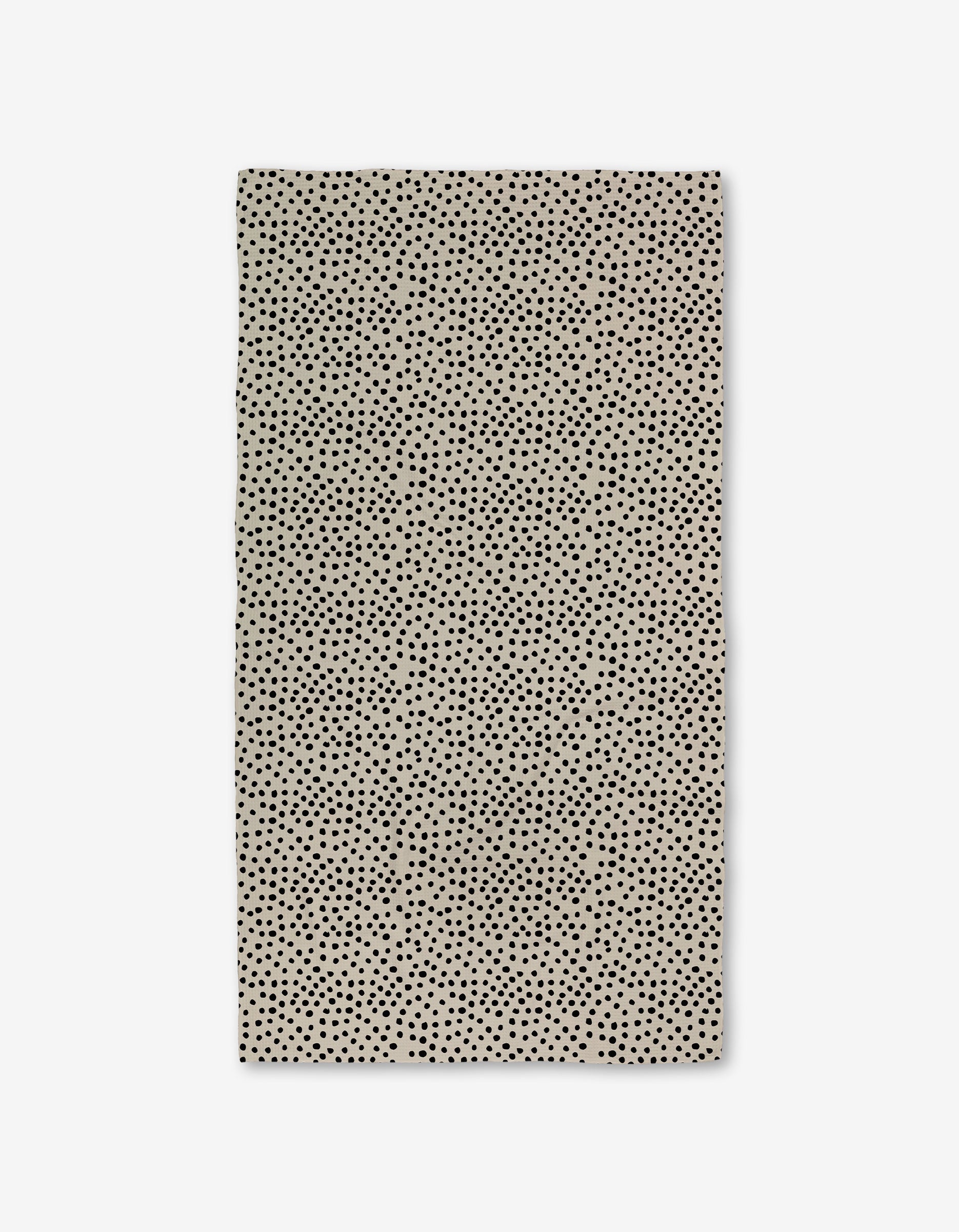 The GEOMETRY Dotty Tan is a rectangular beige napkin with small, evenly spaced black dots, crafted from ultra-absorbent Geoweave fabric and shown flat on a white background.