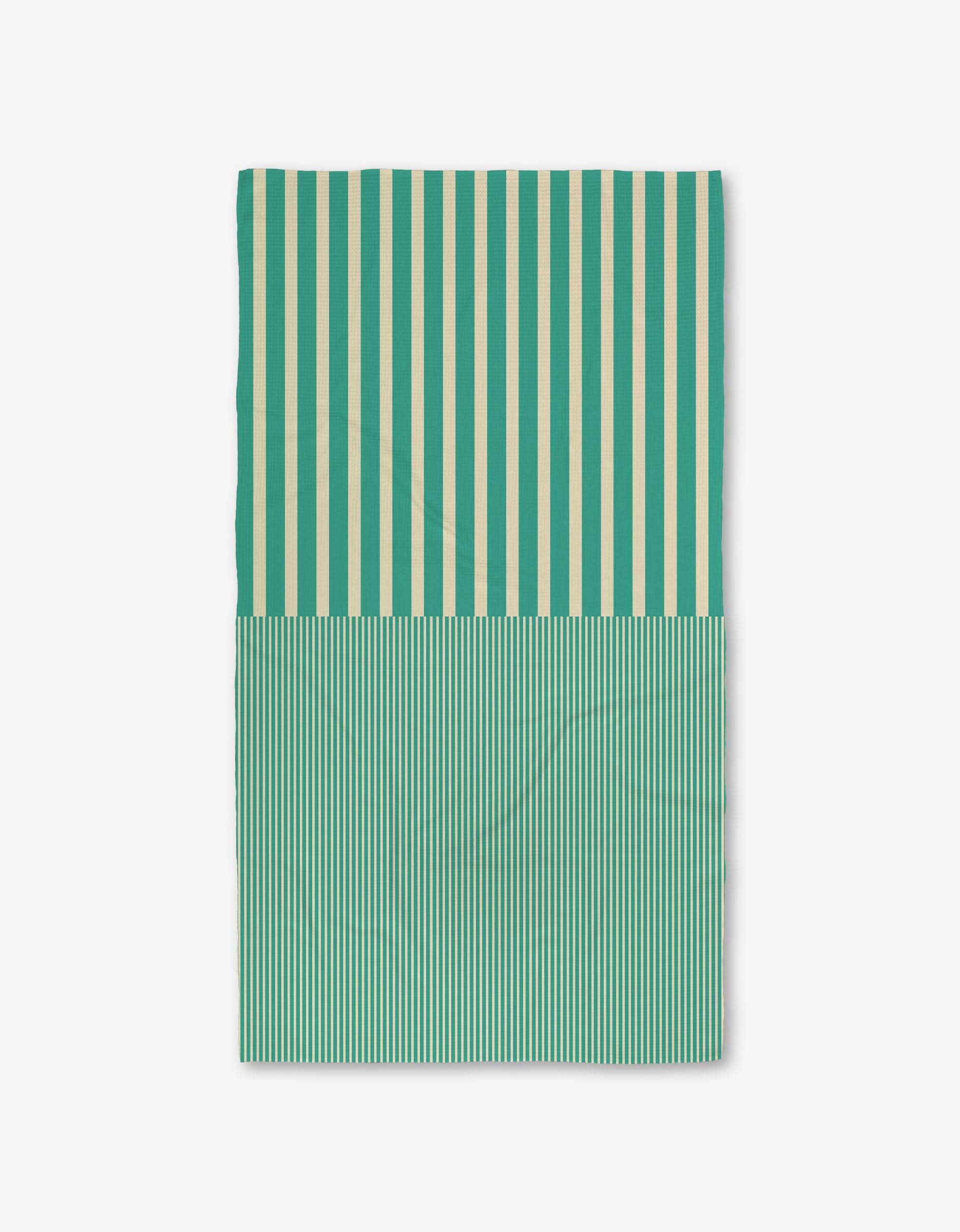 The GEOMETRY Half and Half is a rectangular Luxe Bath Towel featuring vertical teal and cream stripes—wide on top, thin below—made from ultra-absorbent recycled materials, shown on a plain white background.