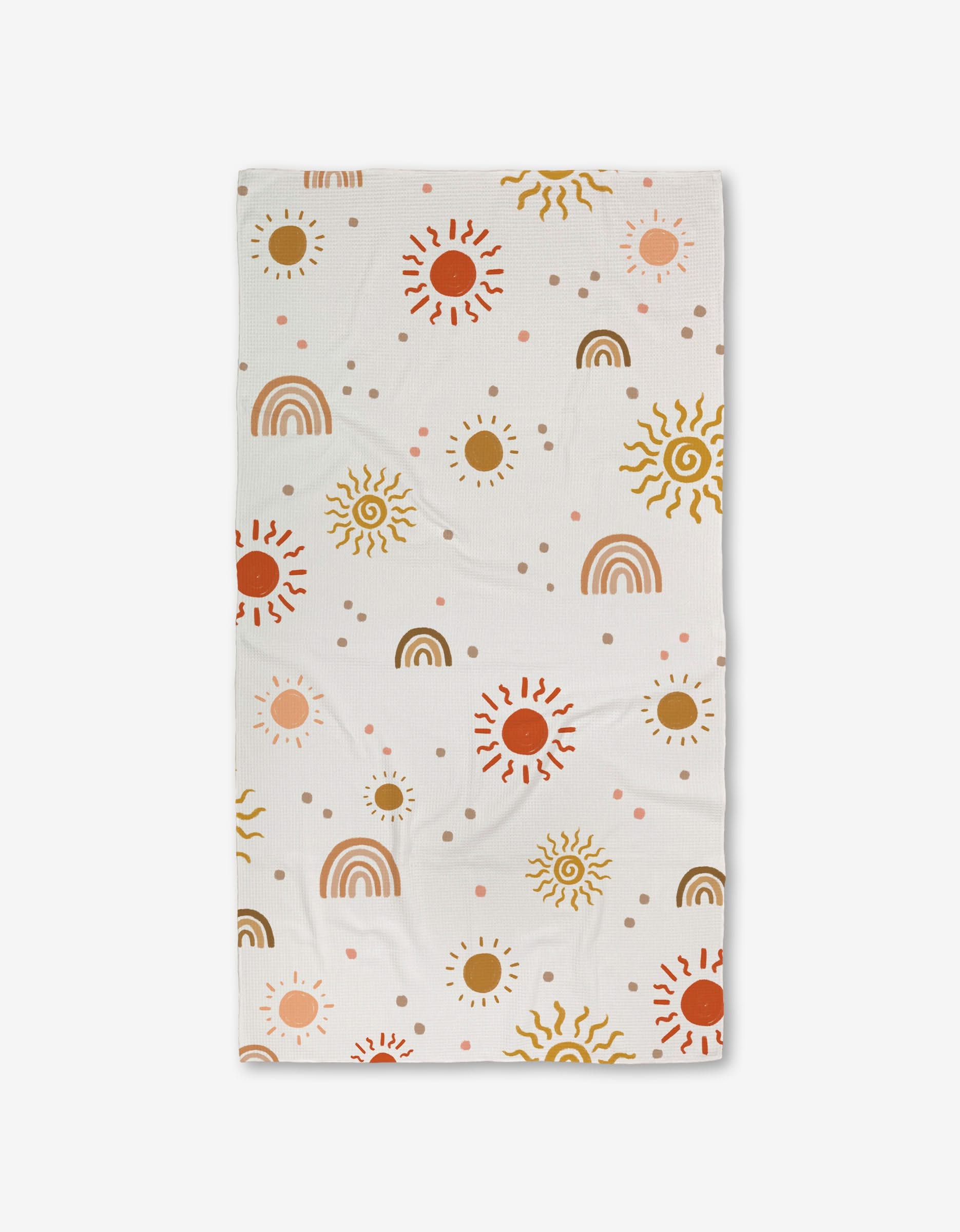 The GEOMETRY Happy Skies Luxe Bath Towel features a cheerful pattern of suns, rainbows, and dots in brown, yellow, red, and pink on ultra-absorbent fabric evenly spread across the white surface.