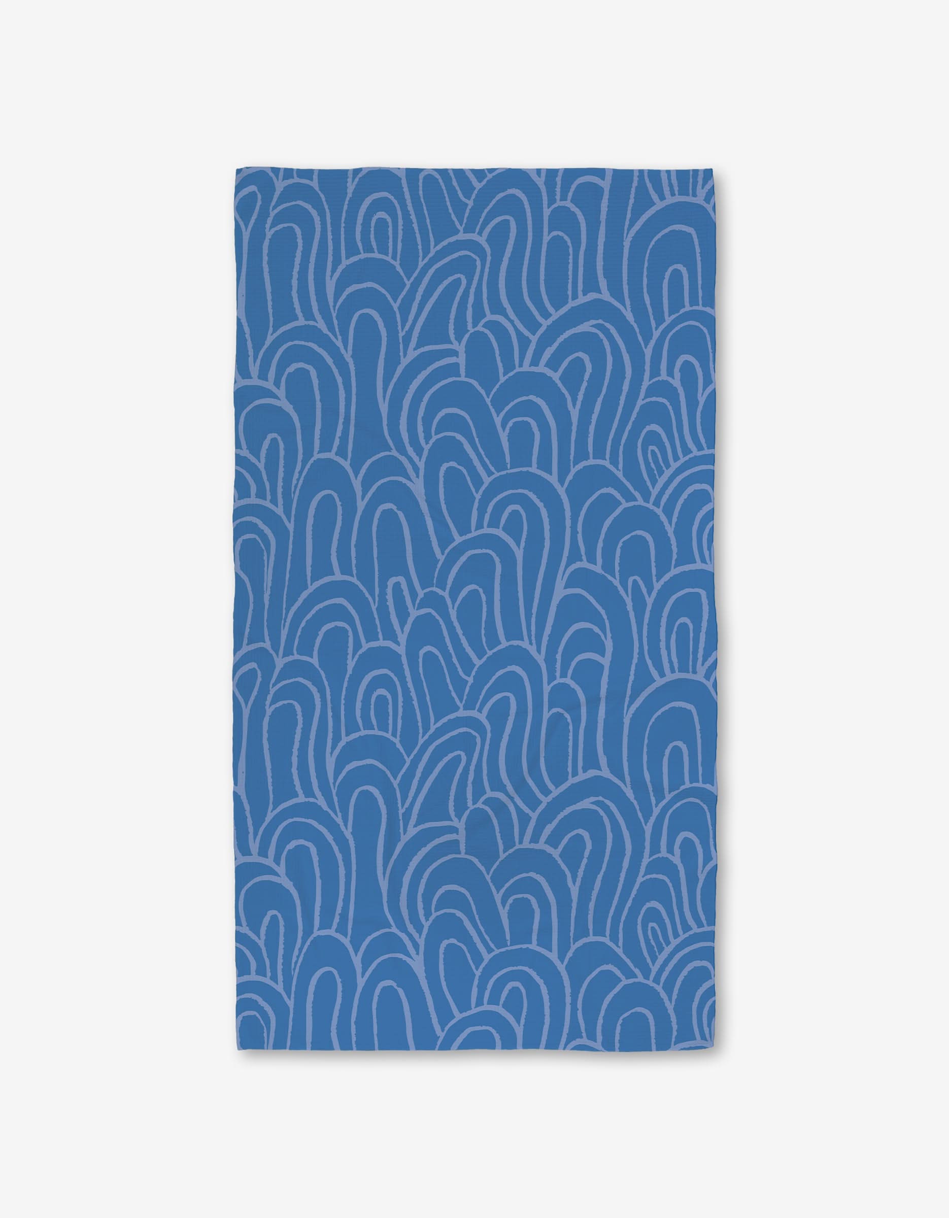 The High Tide Luxe Bath Towel by Sareka Unique is blue with an abstract, wavy line pattern in lighter blue on a white background. Crafted with Geoweave technology, its ultra-absorbent and features a rectangular shape for modern style.