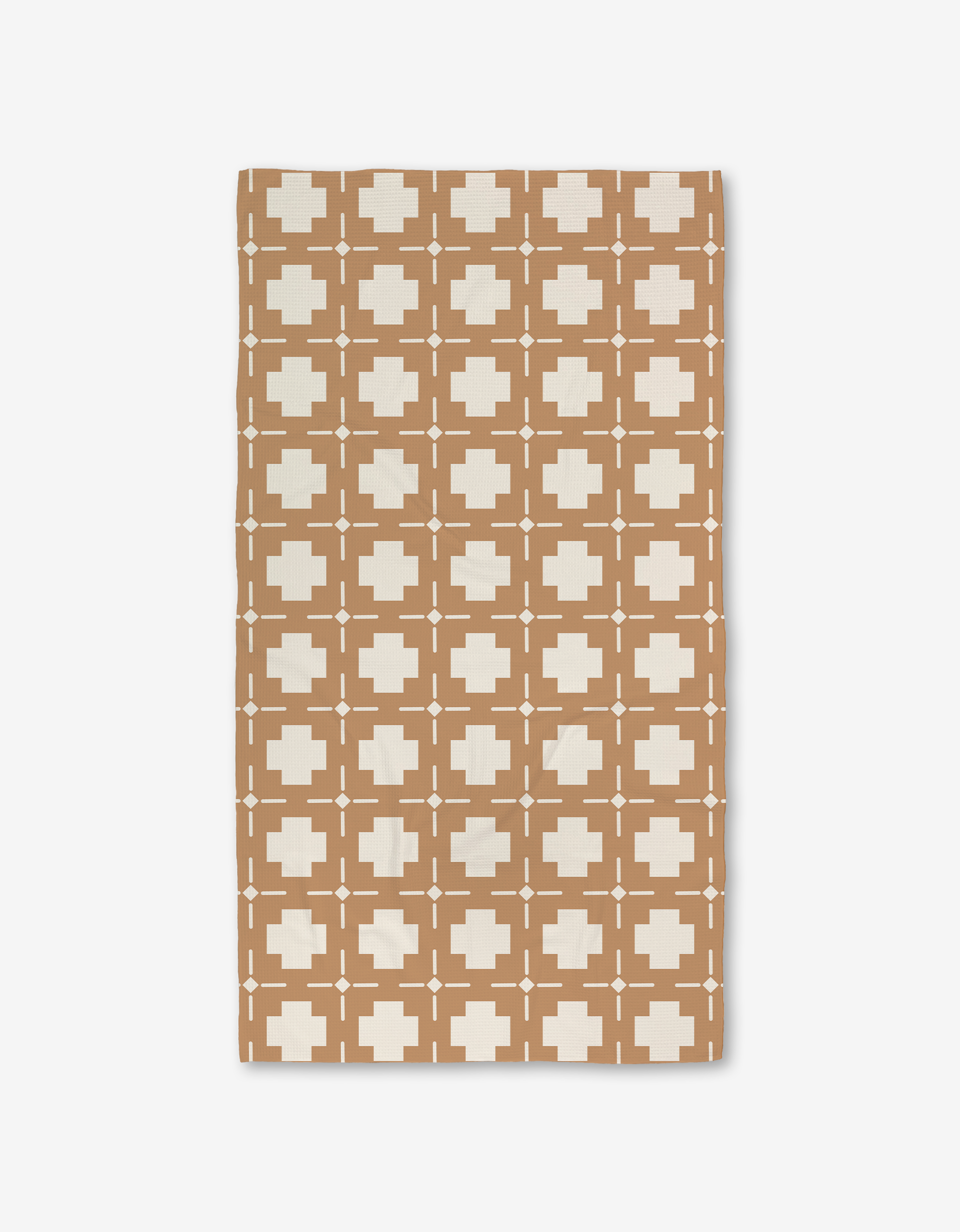 The Jackson rug by Charlie Rowan Designs features a geometric grid of white plus signs and squares with dots on a brown background, crafted with Geoweave technology for ultra-absorbent performance.