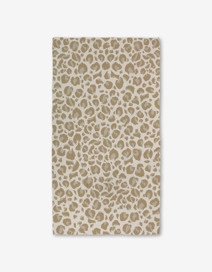 The GEOMETRY Light Leopard rug is a rectangular beige mat with a tan and white leopard print, set on a plain white background and crafted with ultra-absorbent Geoweave Technology for luxurious softness.