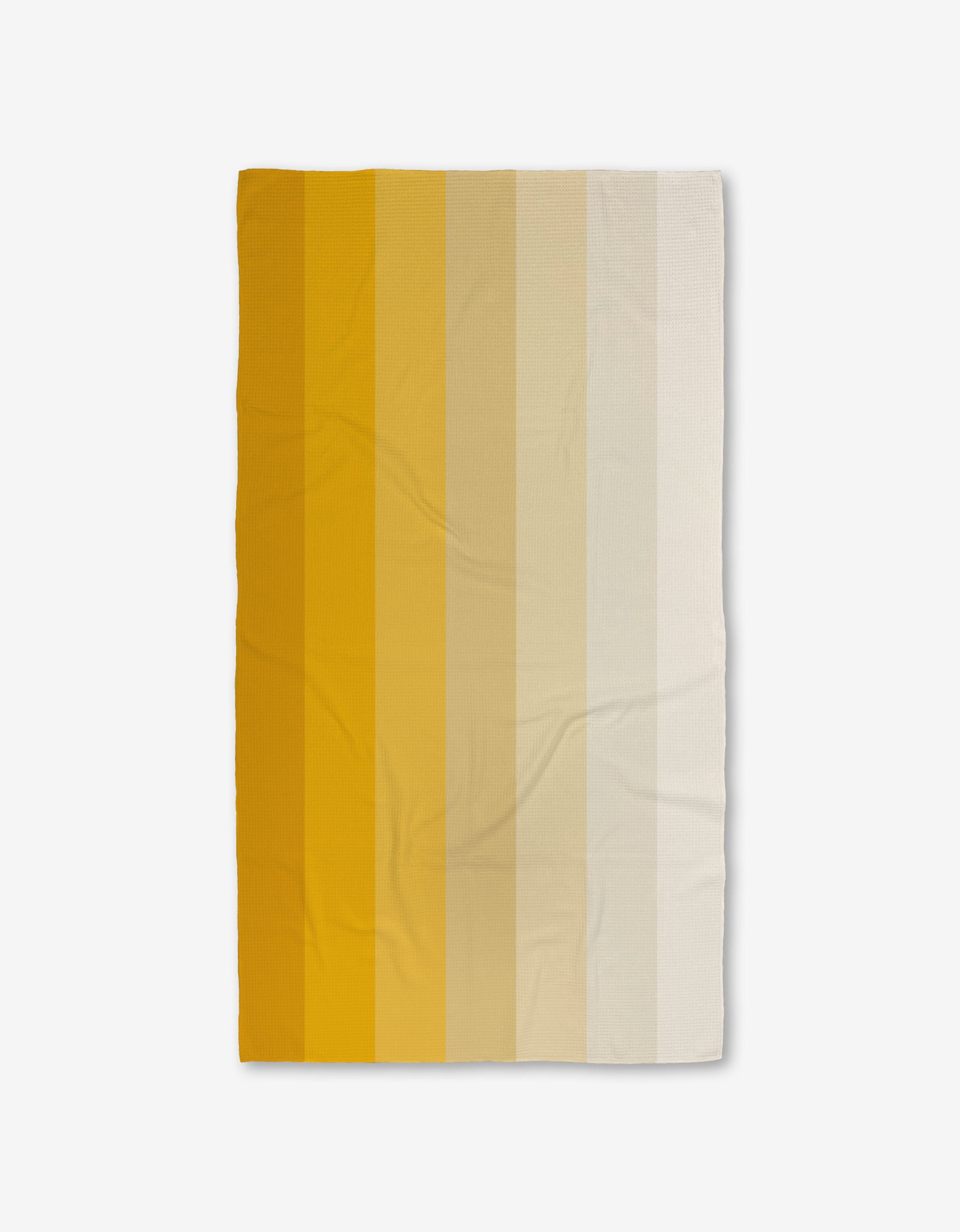 The GEOMETRY Saffron Levels is a rectangular blanket featuring vertical stripes in warm gradient tones from dark mustard yellow to off-white, crafted from recycled materials and shown on a white background.