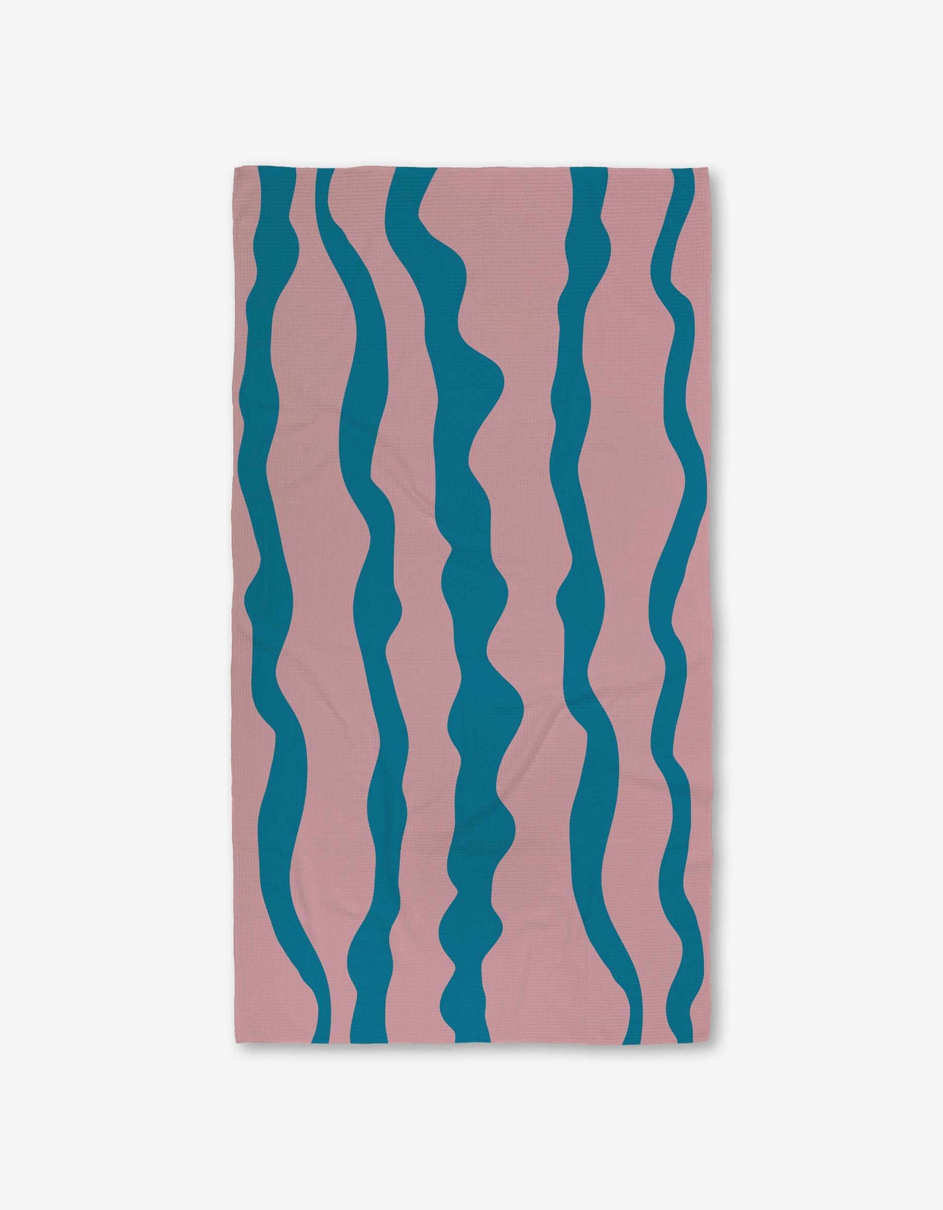 The GEOMETRY Turquoise Twist towel features a pink base with five wavy blue stripes and Geoweave technology, offering ultra-absorbency for those seeking stylish and functional Luxe Bath Towels.