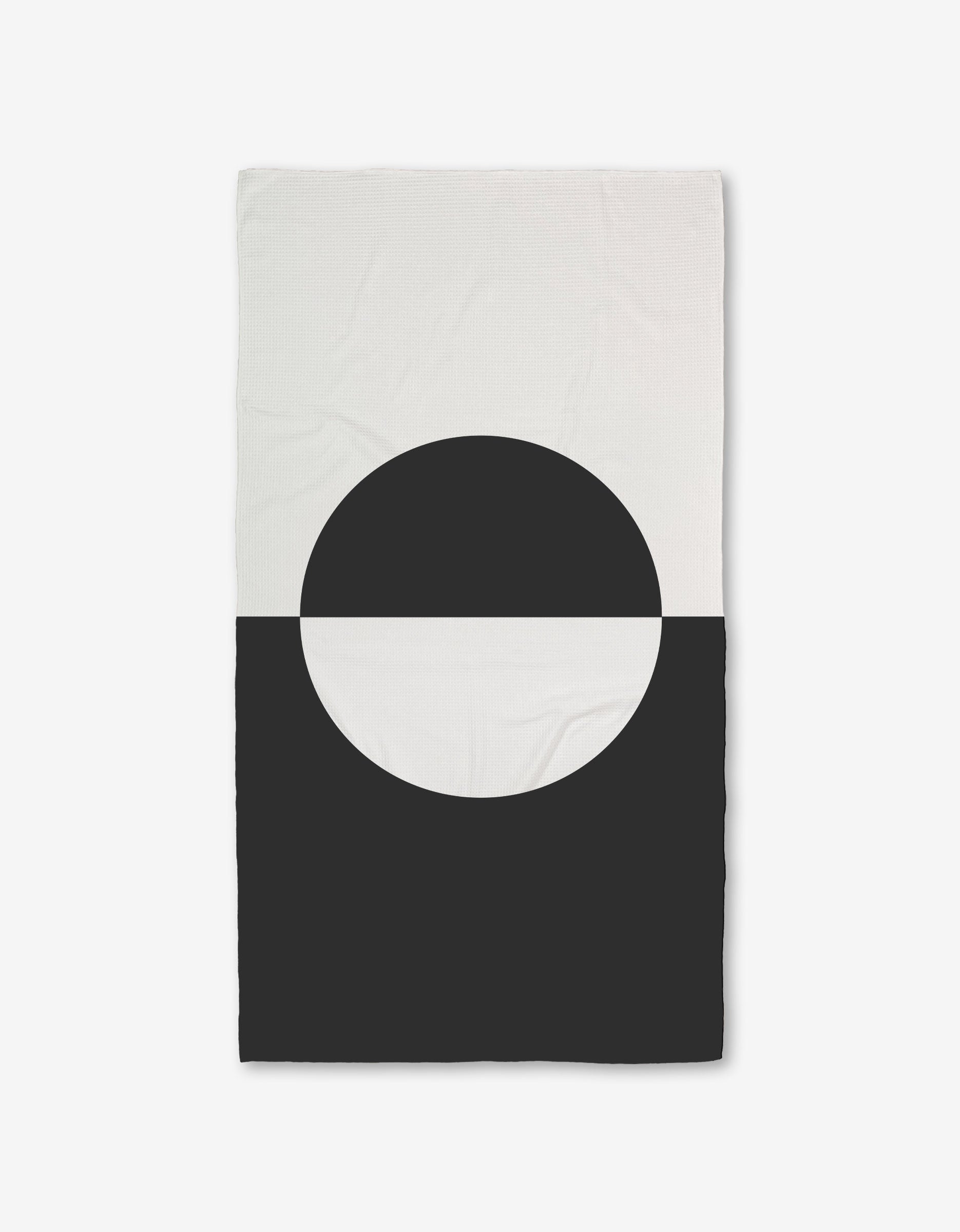 The GEOMETRY Yin Yang Bath Towel features a minimalist geometric design with a black semicircle on the white lower half, creating bold contrast, and is crafted with ultra-absorbent Geoweave technology.
