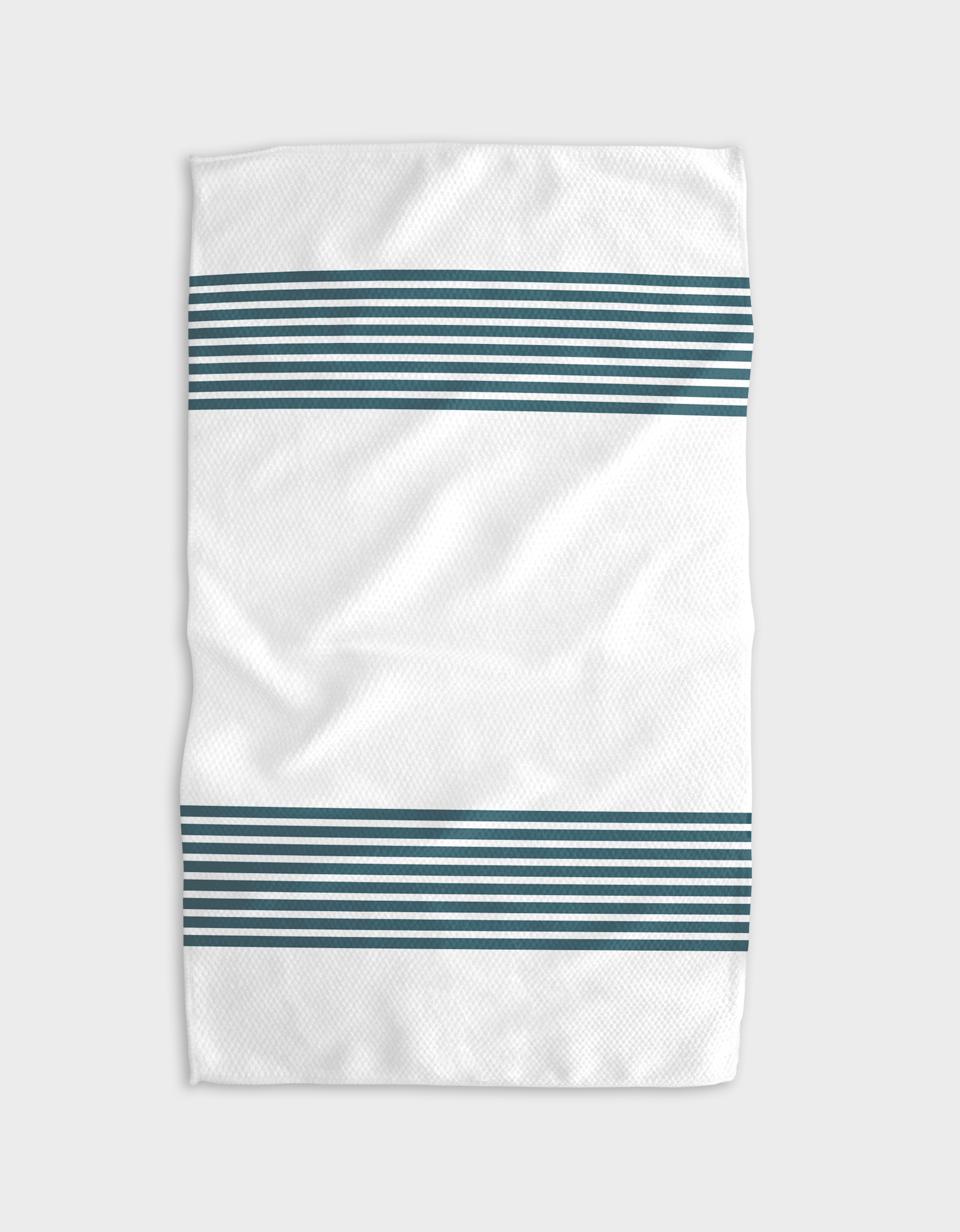 The Buy Guides Bold Blank Space - Emerald is a white kitchen towel with two sets of horizontal dark teal stripes near the edges, shown slightly wrinkled against a plain light gray background.