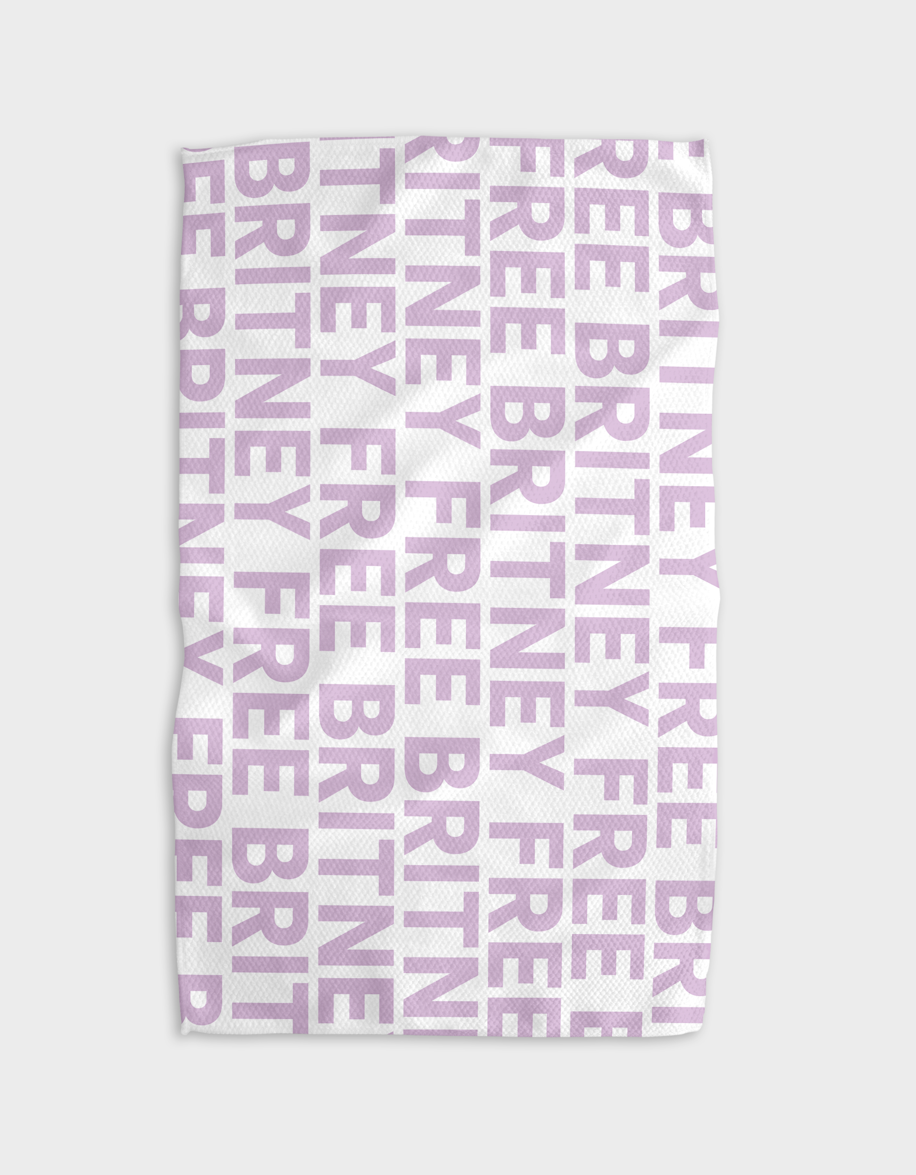 The Britney tea towel by The Buy Guide is made from recycled materials, with bold light purple FREE BRITNEY text in a grid pattern. Its quick-drying, textured fabric gives a stylish, slightly wrinkled look.