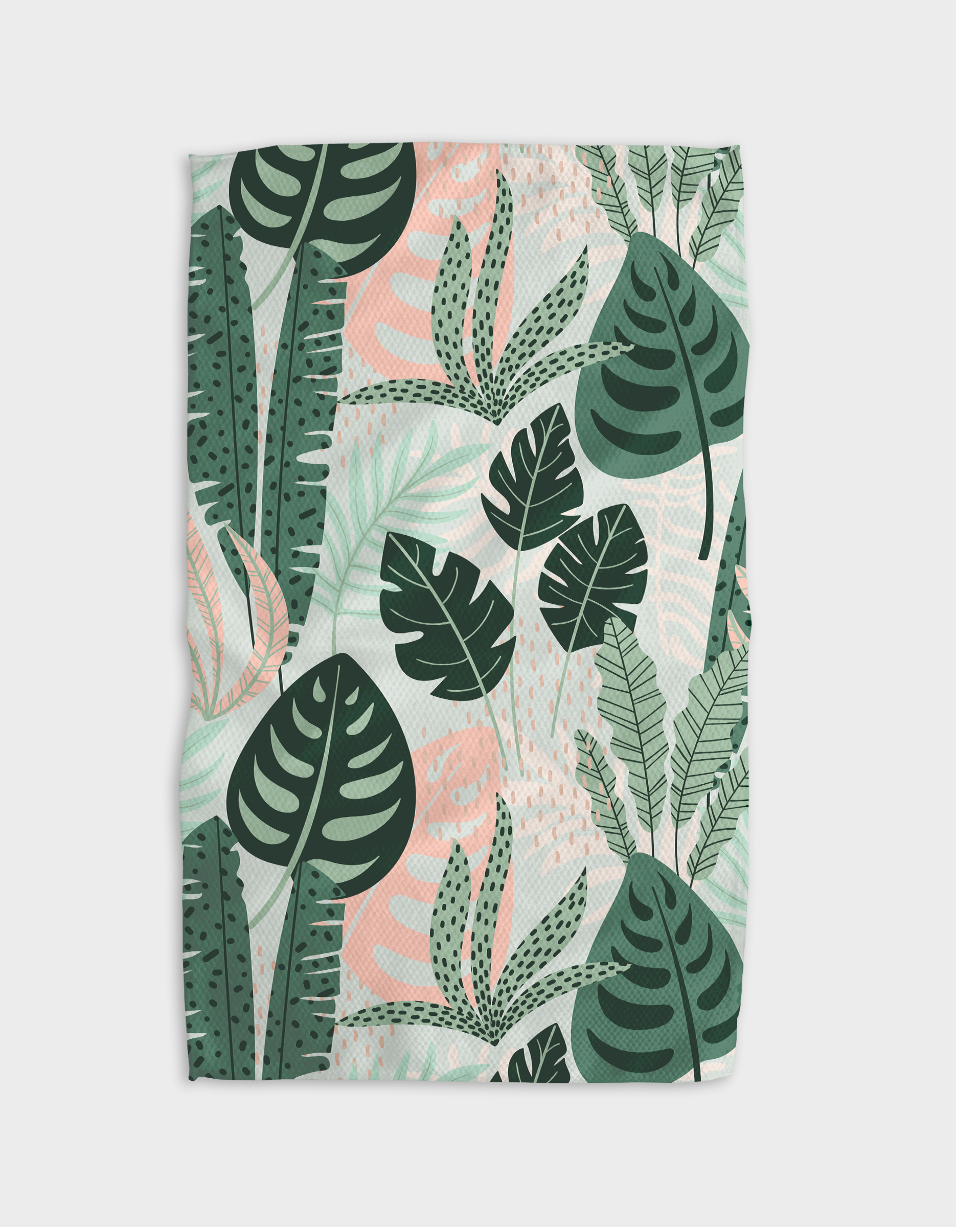 Diedre is a blanket made from post-consumer recycled materials, featuring a tropical leaf pattern with monstera, palm, and other green botanical elements plus subtle pink accents on a light background.