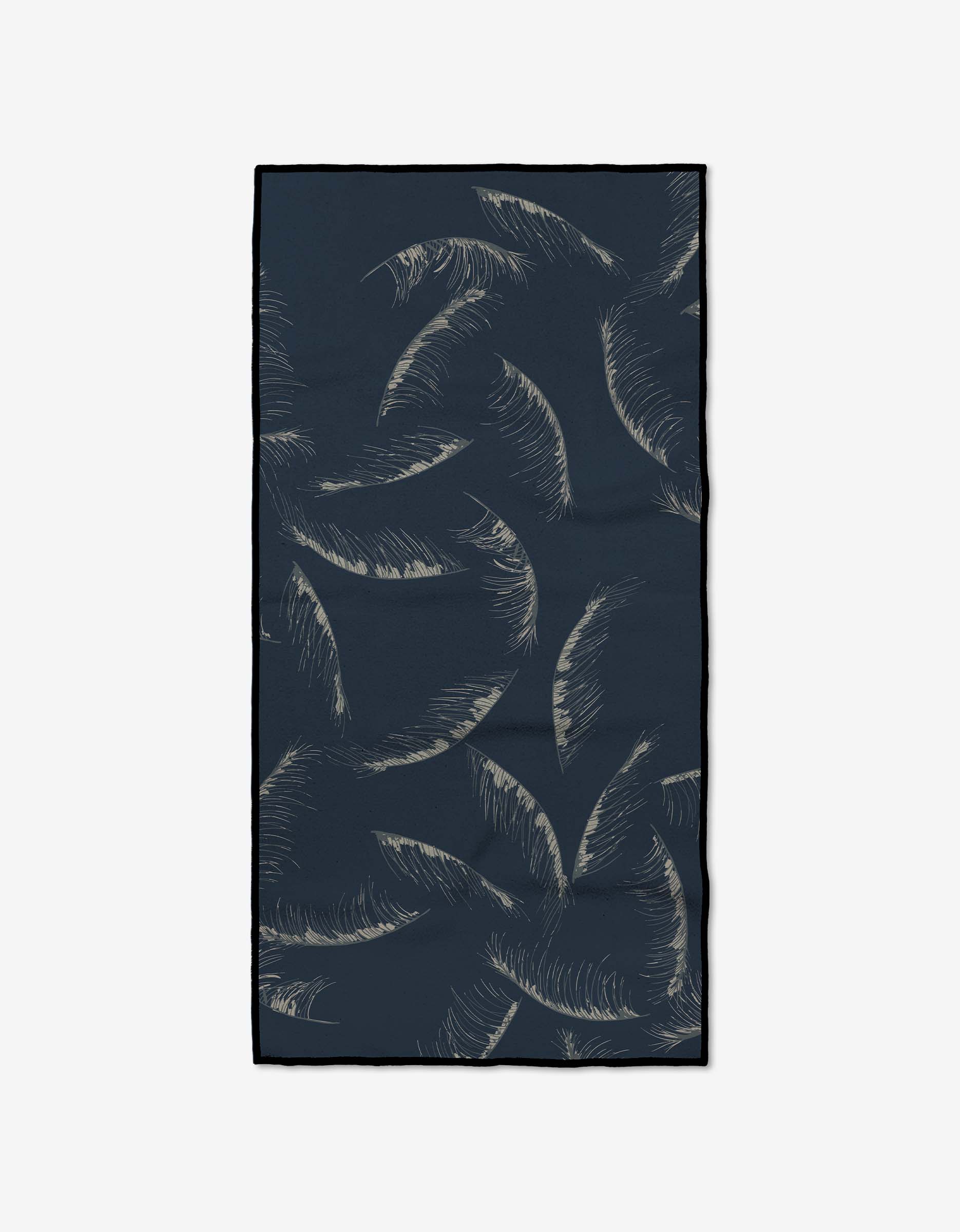 The GEOMETRY Due North Midnight Fitness Towel is rectangular and dark blue with beige palm leaves. Made from ultra-absorbent Geoweave fabric, it features a minimalistic design and black-outlined edges.