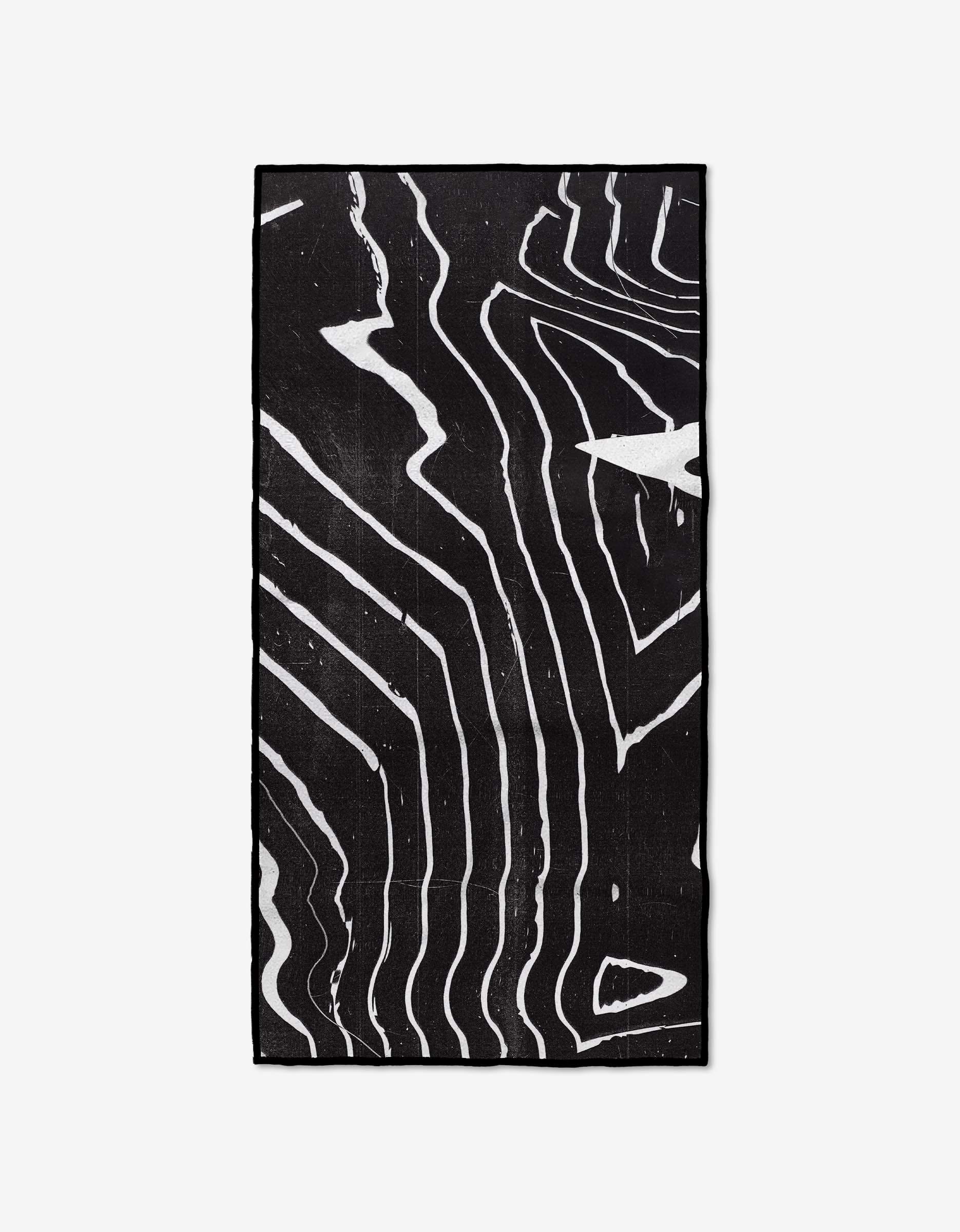 The GEOMETRY Ting is a rectangular black fitness towel made from Geoweave Fabric, featuring abstract wavy white lines that resemble topographic or wood grain patterns on a plain white background.