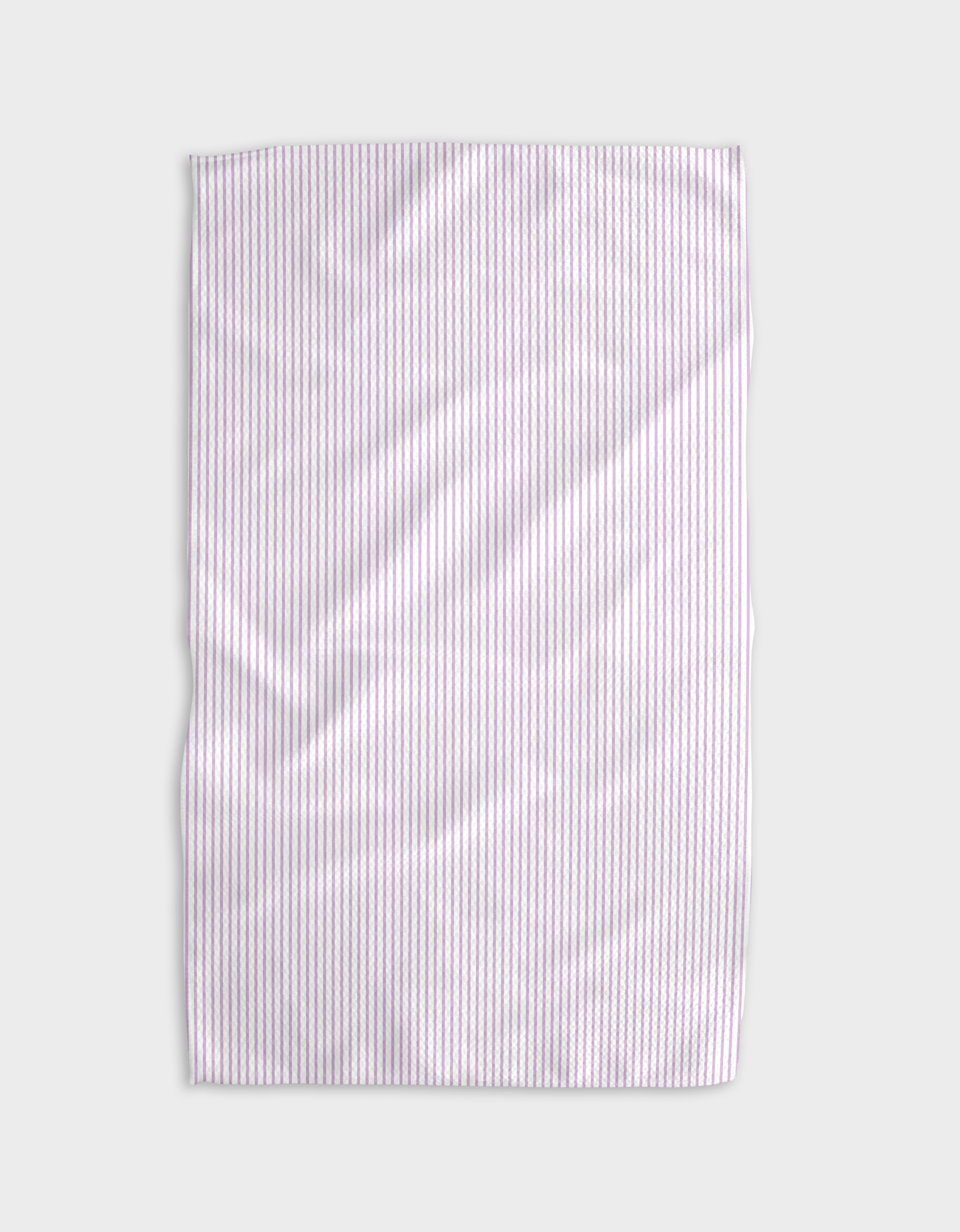 The Buy Guides Get In Line - Lilac Tea Towel features thin vertical lilac and white stripes on a light gray Geoweave fabric, with visible creases and folds.