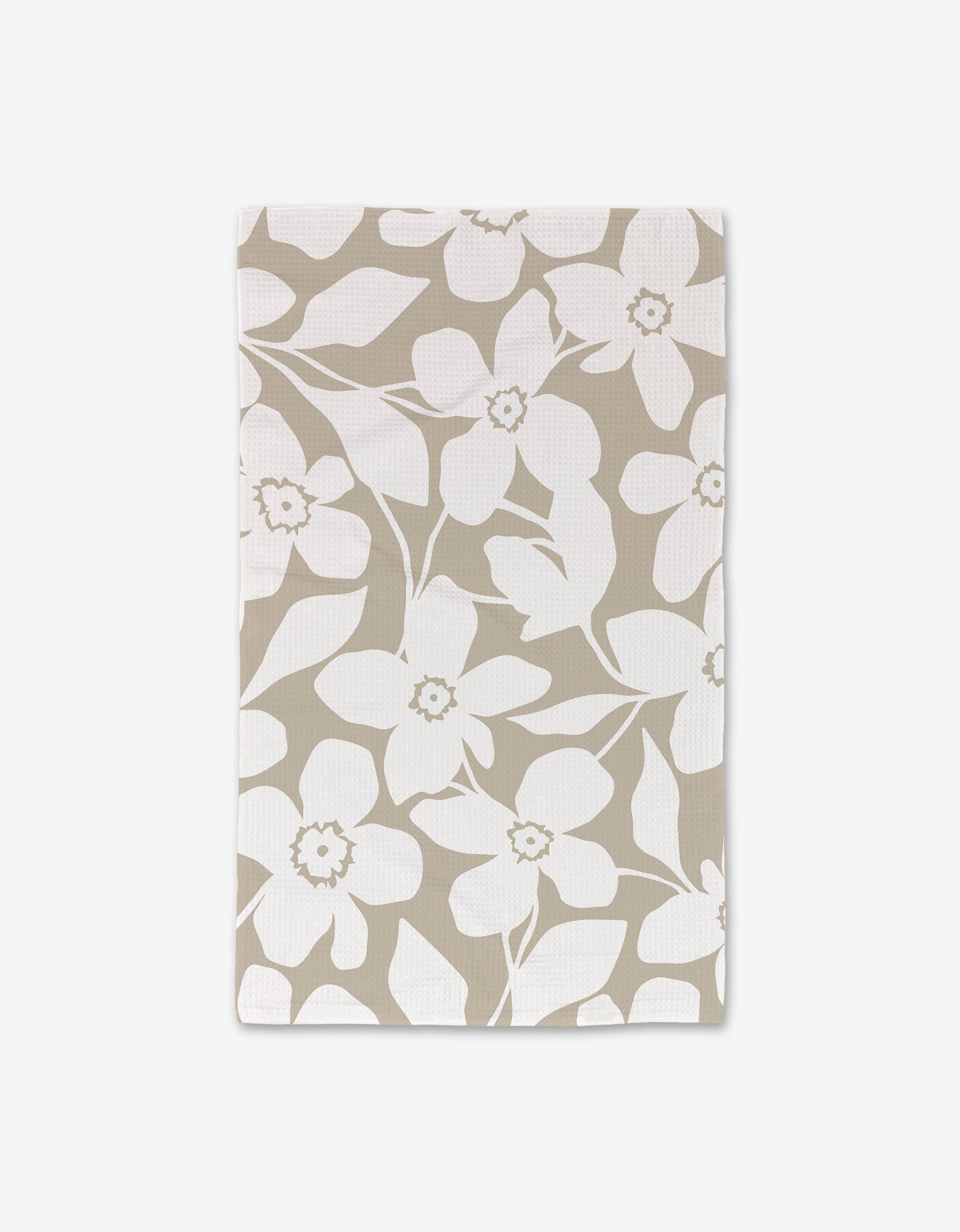 The GEOMETRY Big Tan Flowers dish towel, rectangular and beige with a white floral pattern of large flowers and leaves, is crafted with ultra-absorbent Geoweave technology and shown flat on a white background.
