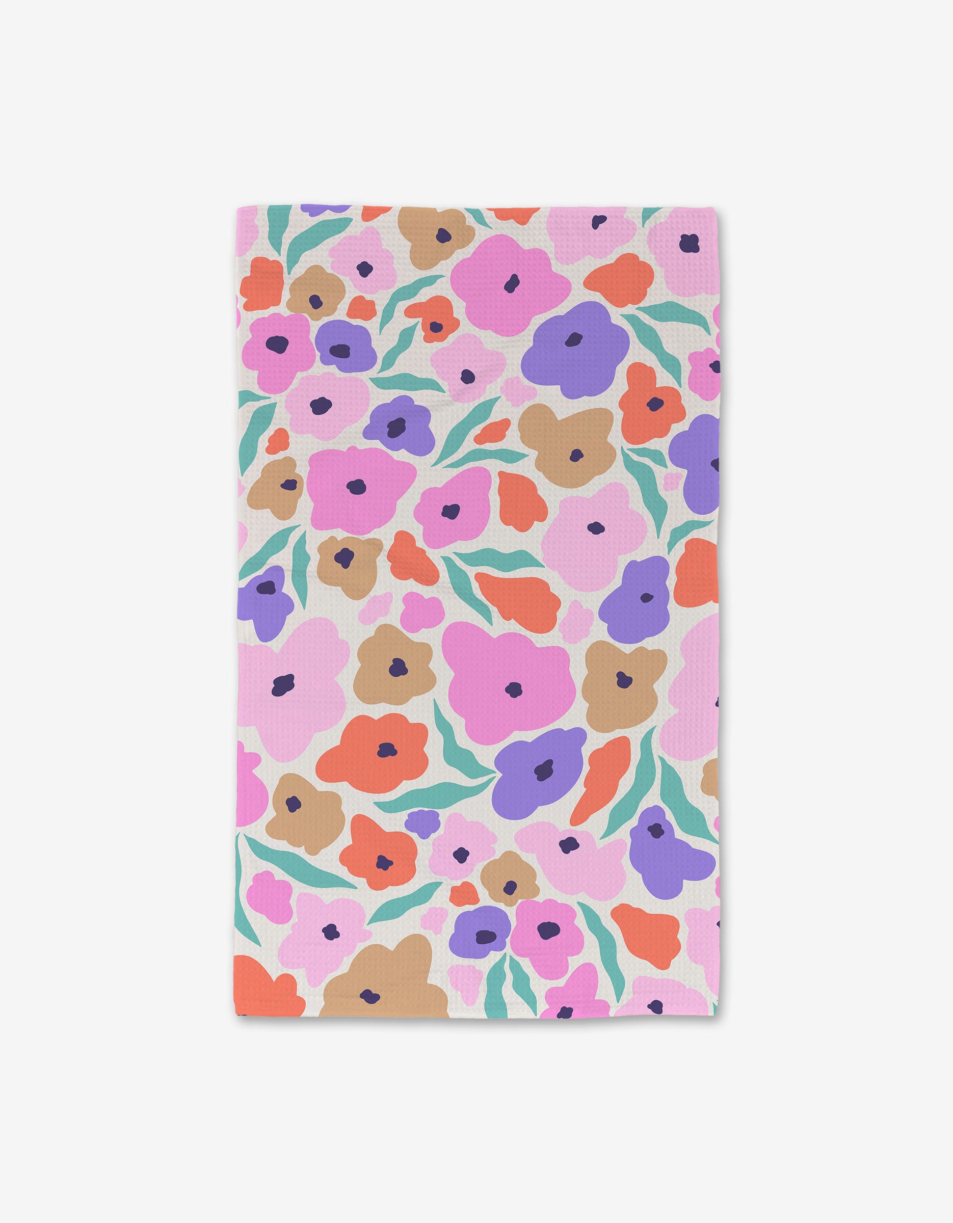 The GEOMETRY Blossoming Love Luxe Hand Towel displays a vibrant floral pattern in purple, pink, orange, and brown with green leaves on light pink. Ultra-absorbent and rectangular, its shown laid flat on a white surface.
