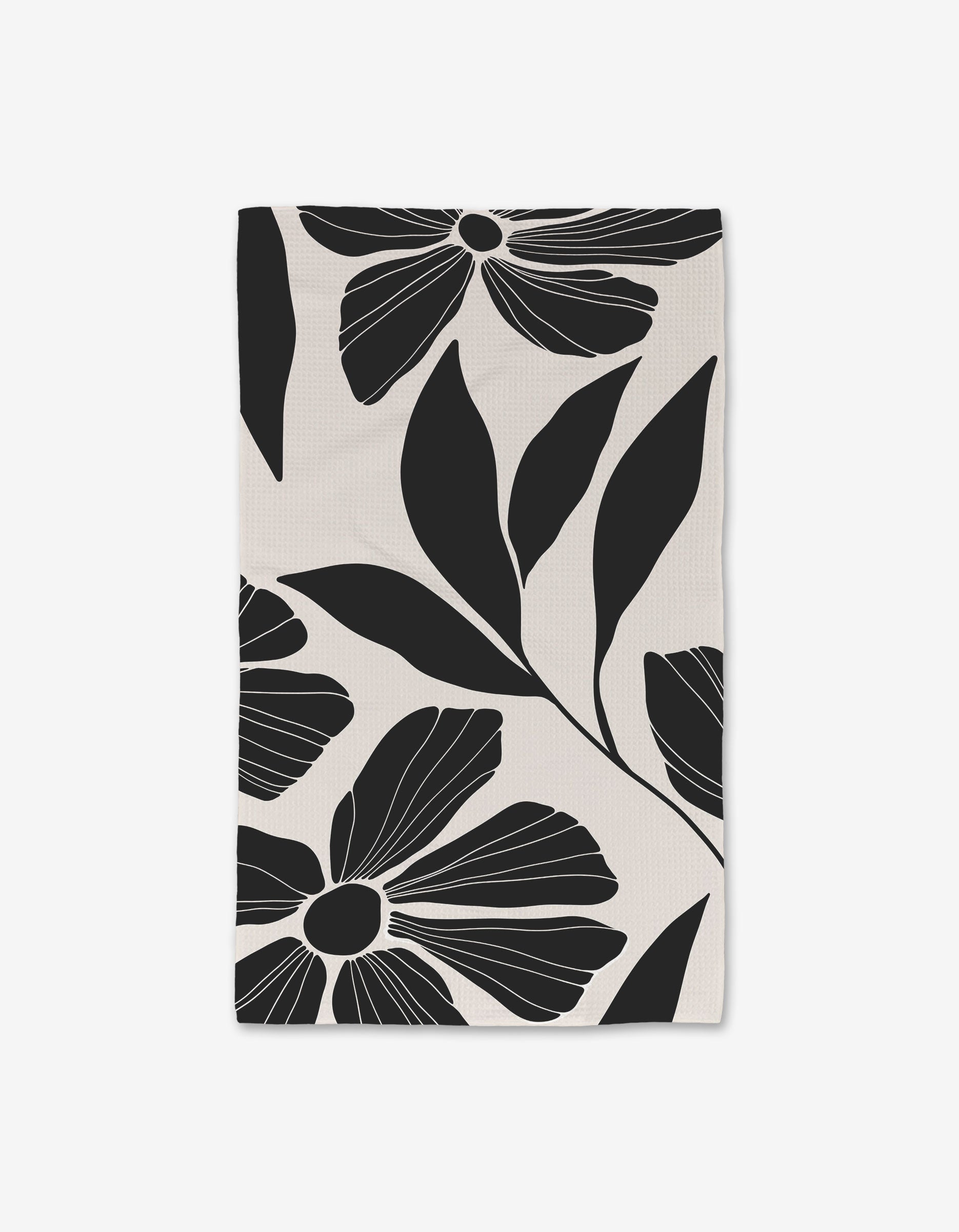 The GEOMETRY Harmony Hand Towel is rectangular and features a bold black and white floral pattern on a light background, crafted with ultra-absorbent Geoweave technology.