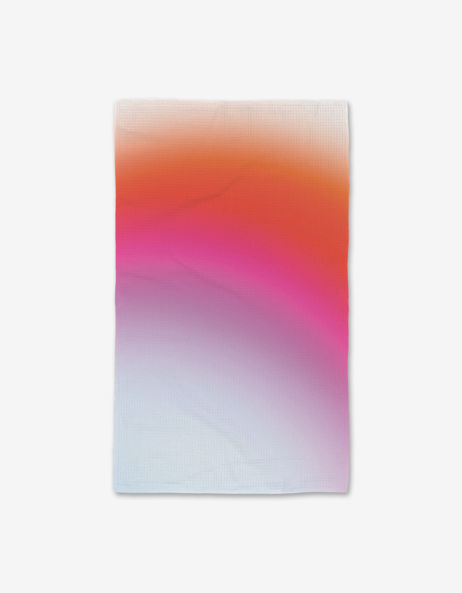 A rectangular GEOMETRY Lively Hue hand towel with Geoweave technology and a gradient from orange (top) to pink (middle) to light blue (bottom), shown on a white background.