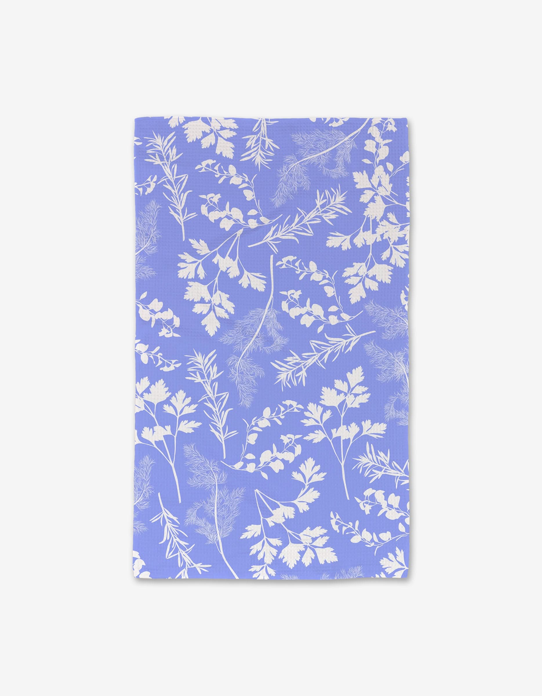 The GEOMETRY Periwinkle Garden Hand Towel is a rectangular, lavender towel with a white leafy botanical print, made from ultra-absorbent recycled materials and shown flat against a white background.