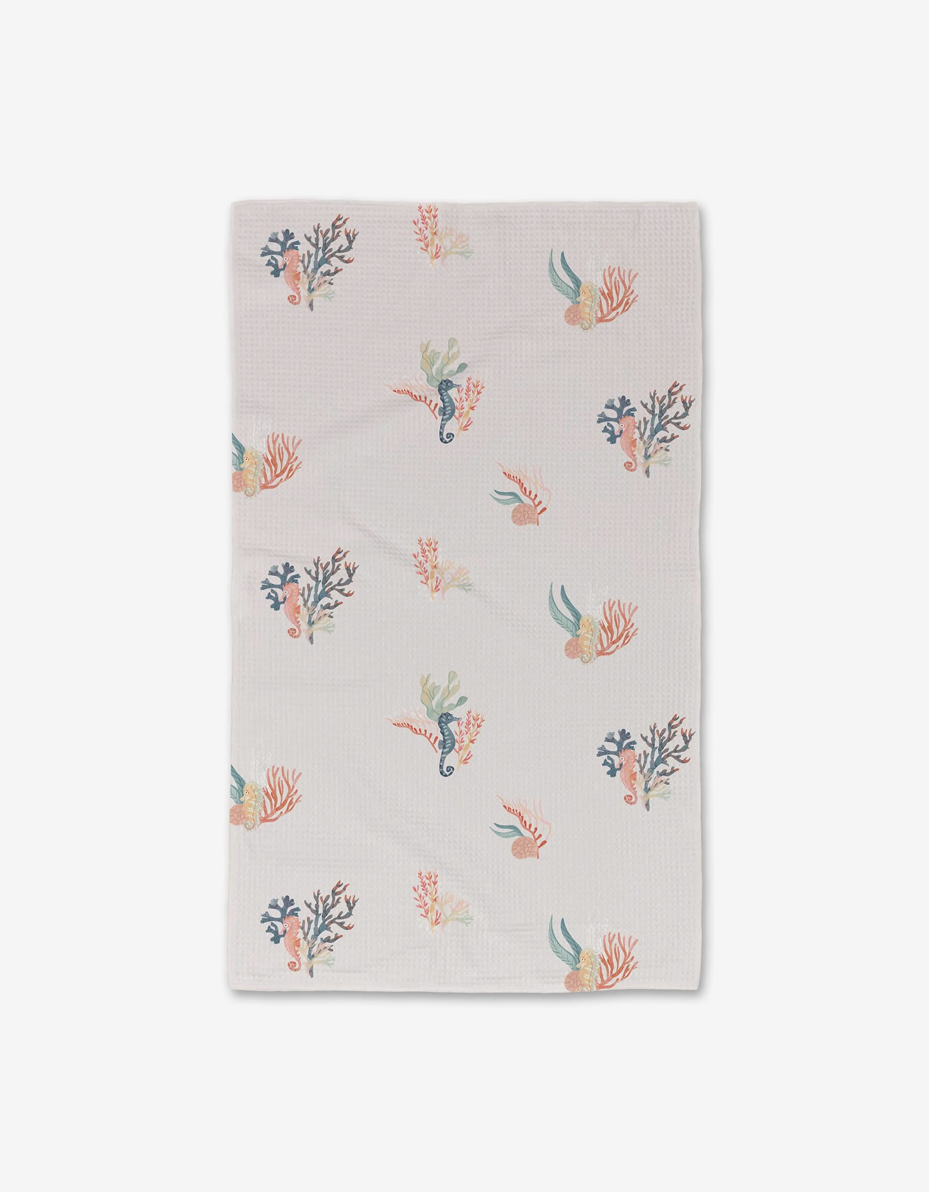 The Seahorse Serendipity towel by Janna Sue Design is a white, ultra-absorbent towel adorned with colorful coral, seaweed, seahorses, and small fish illustrations.