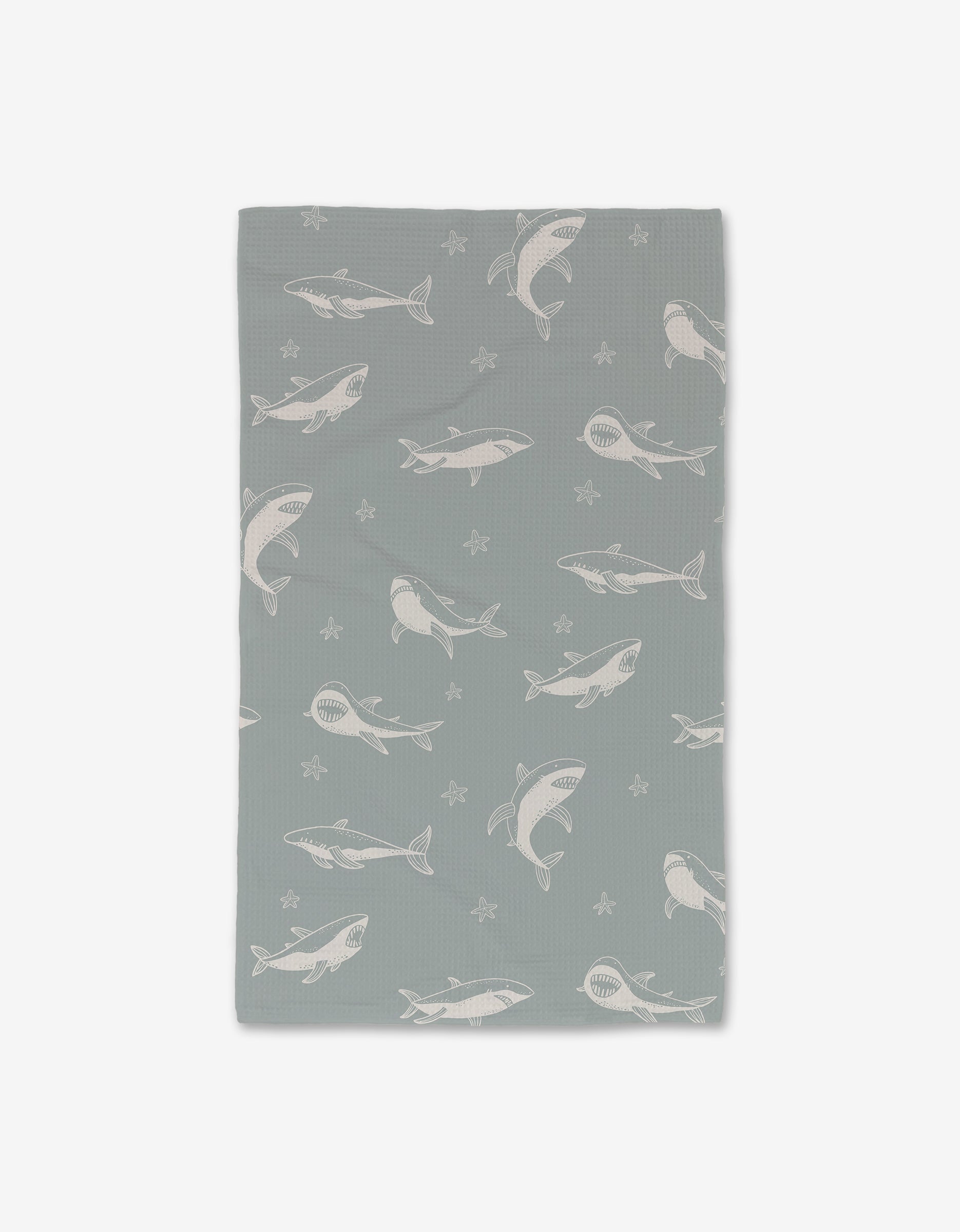 The Toothy Tales blanket by Janna Sue Design is a gray rectangle with white sharks and starfish, made from ultra-absorbent material for a cozy blend of style and function.