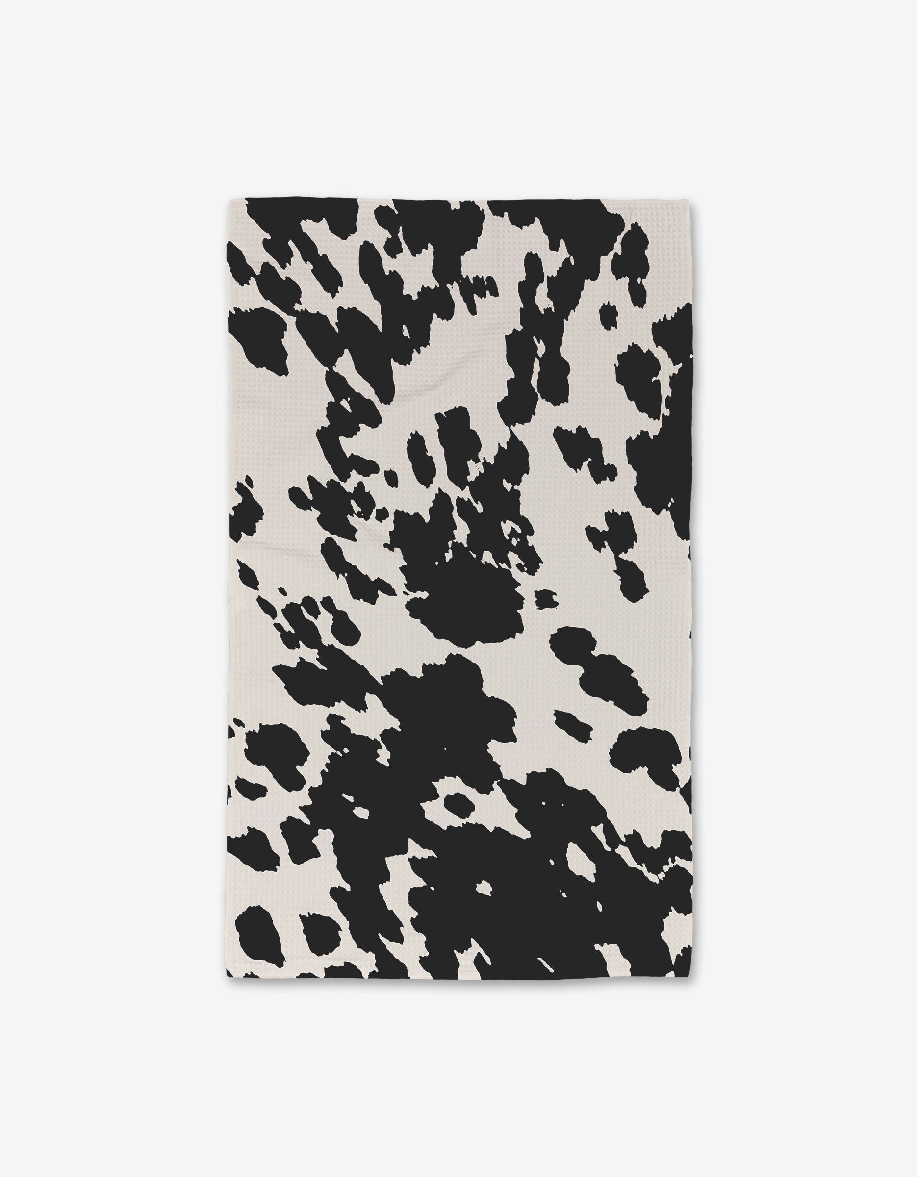 The Wild West Luxe Hand Towels by GEOMETRY feature an ultra-absorbent rectangular cloth with a black and white cow print, crafted from recycled materials.