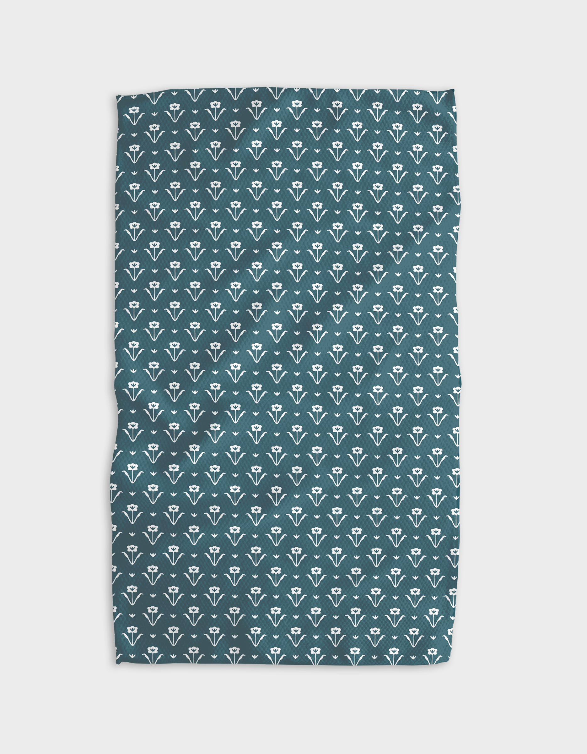 The Buy Guide’s Ladylike - Emerald Tea Towel features a repeating pattern of small white stylized florals on teal Geoweave™ fabric, with slight wrinkles, shown against a white background.