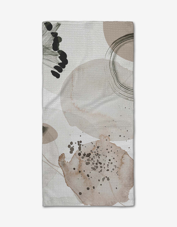 The Hayden Abstract Bar Towel by Kailee Wright features abstract beige, brown, and black shapes with dotted patterns on a light background, made from soft Geoweave fabric for optimal absorbency.